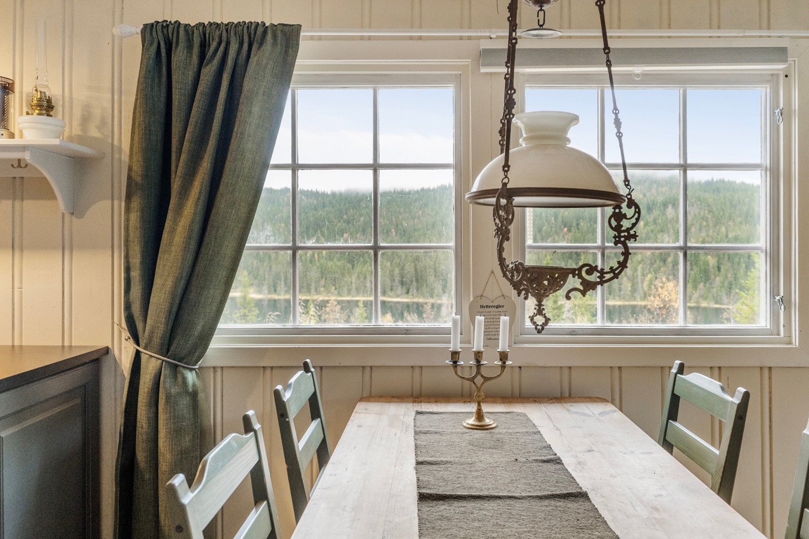 Plass til stort spisebord mellom kjøkkenet og stuen, med utsikt til de fine omgivelsene ute Galleribilde