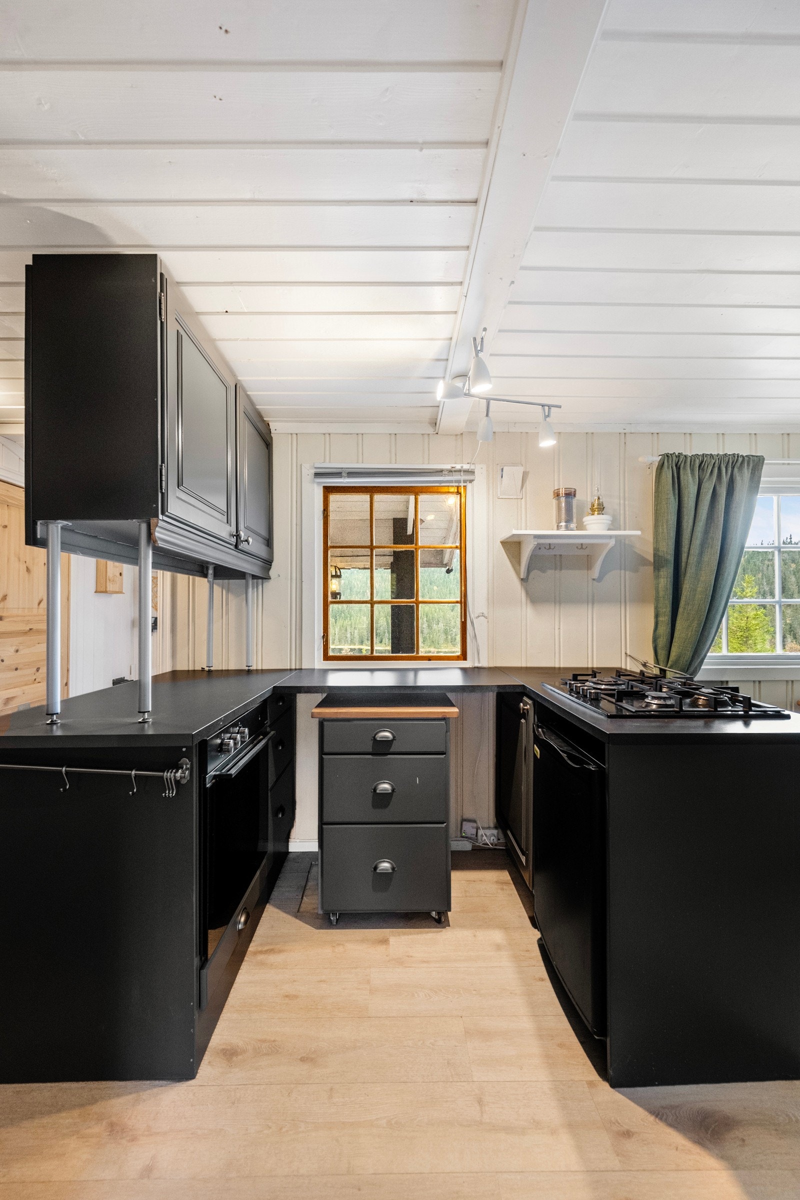 Det er plass til gasskokeplate og gasskjøleskap, og en halvøy med skaper en naturlig avgrensning mellom stue og kjøkken Galleribilde