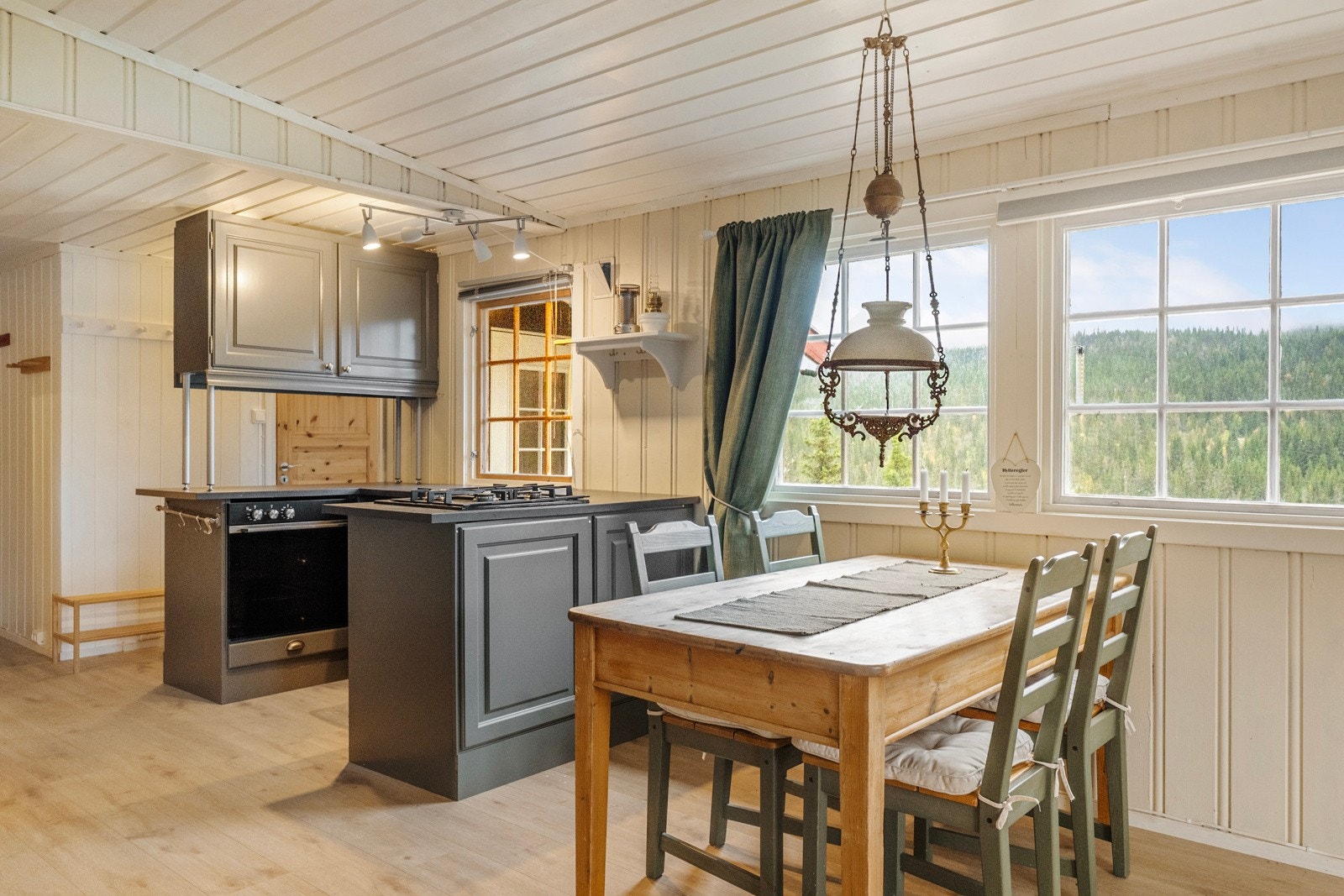 Kjøkkenet fremstår pent og praktisk, med grå profilerte fronter, laminert benkeplate og både under- og overskap som gir godt med oppbevaringsplass Galleribilde