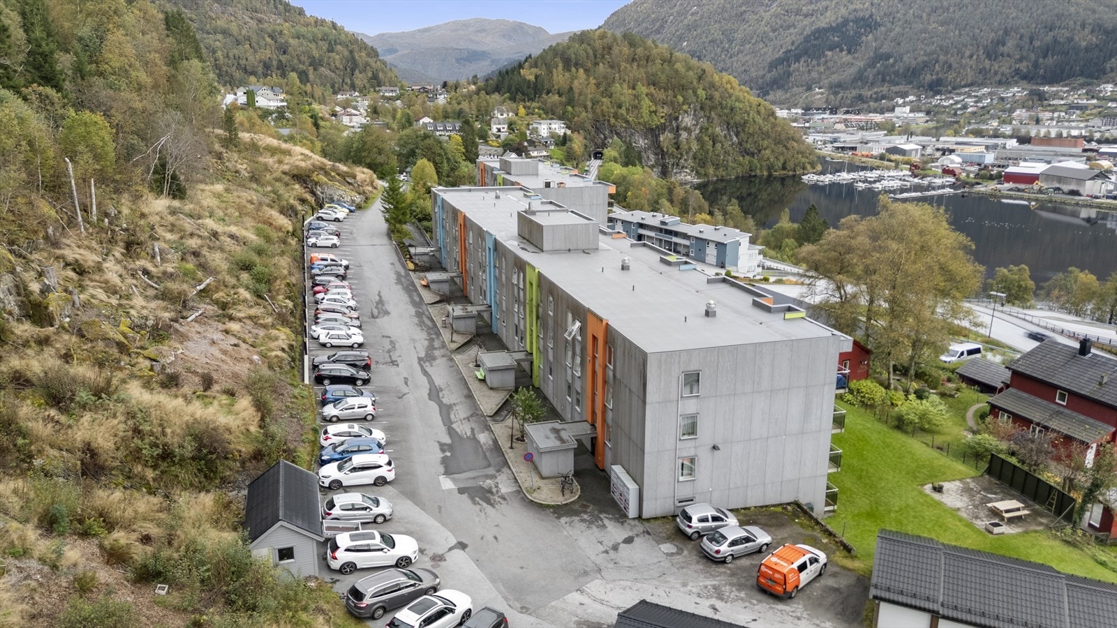 Adkomst inn i burettslaget på oppsida av blokka - her er felles parkeringsplass Galleribilde