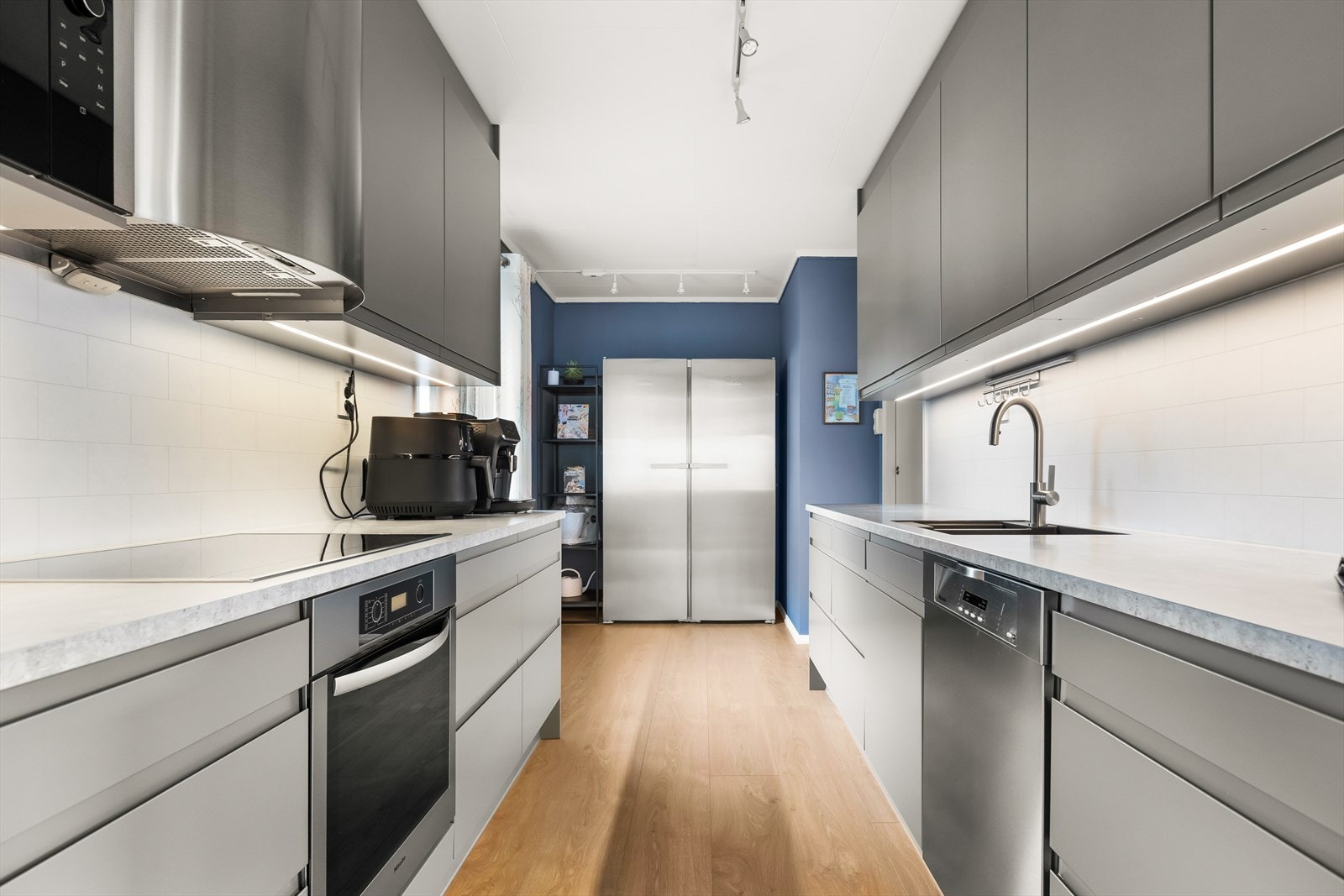 Stilrent kjøkken fra Norema med integrerte hvitevarer og god skapplass. Galleribilde