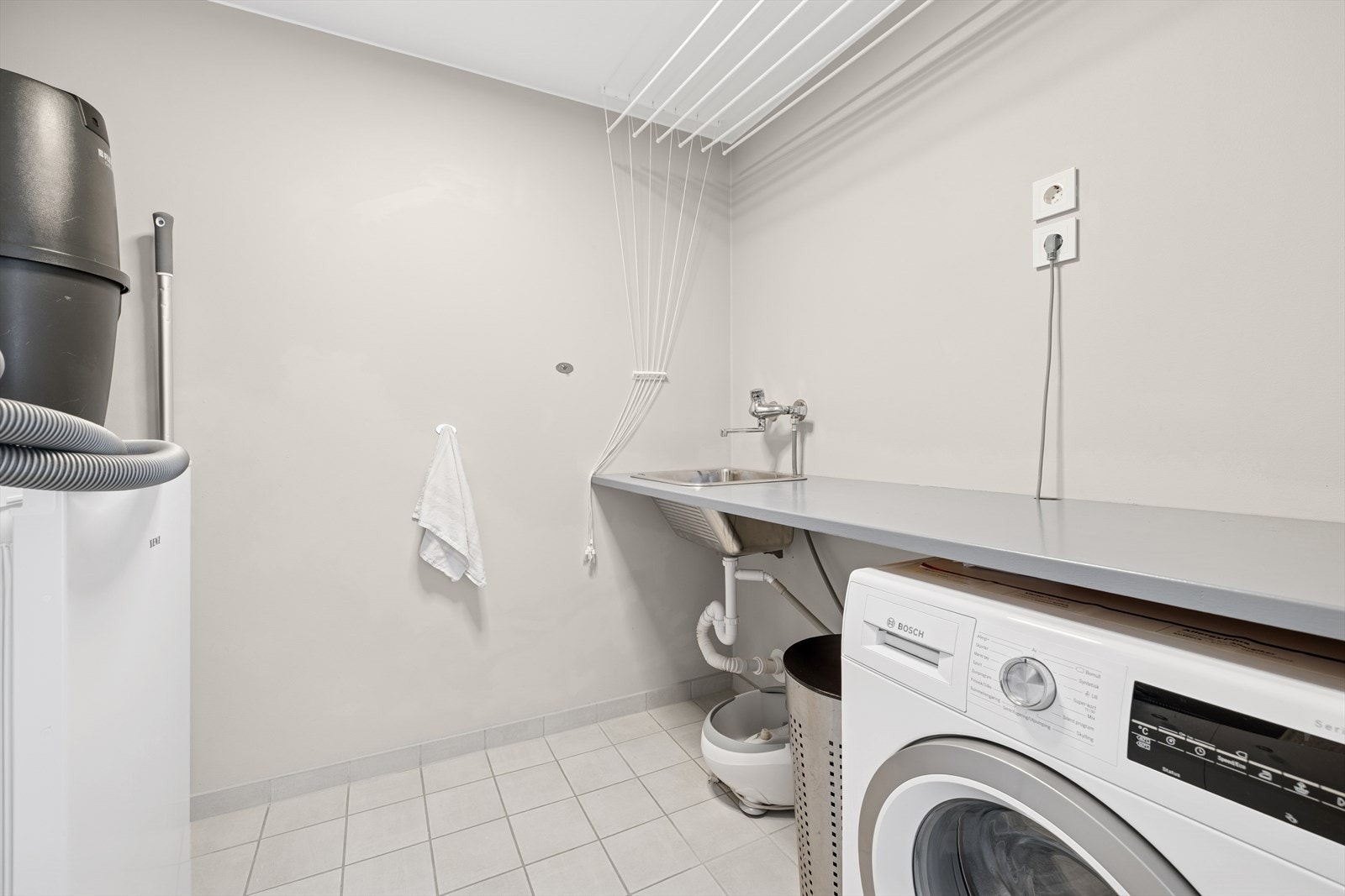 Vaskerommet har flislagt gulv og malte vegger. Rommet er utstyrt utslagsvask i rustfritt stål, benkeplate, samt opplegg for vaskemaskin. Galleribilde