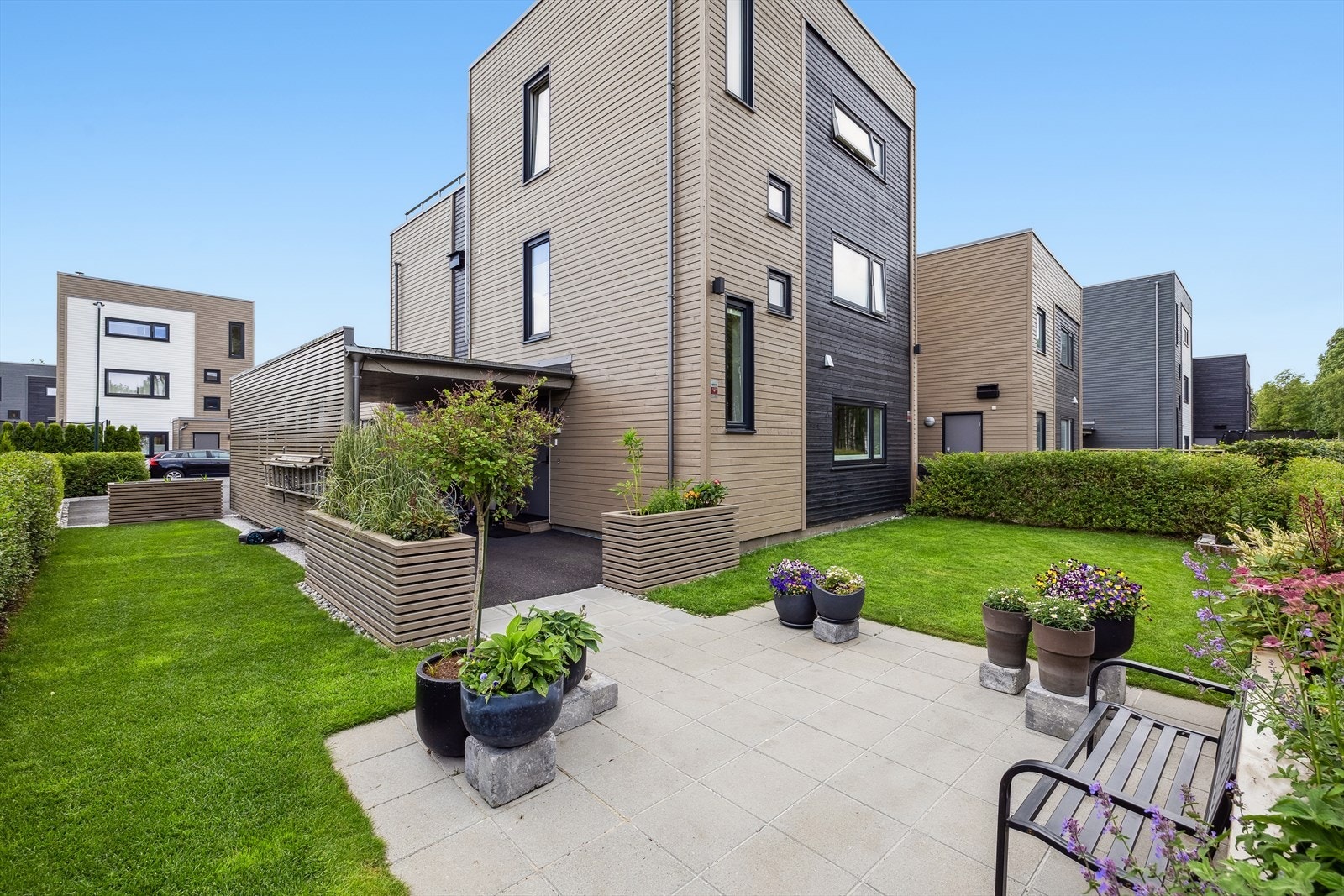 Tomten er pent opparbeidet med gressplen, hekk, flere uteplass, samt diverse beplantning i kasser. Galleribilde