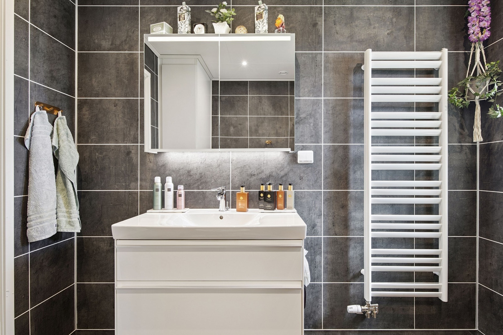 Servantskap med slette fronter og speilskap med integrert belysning gir både stil og funksjon. Galleribilde