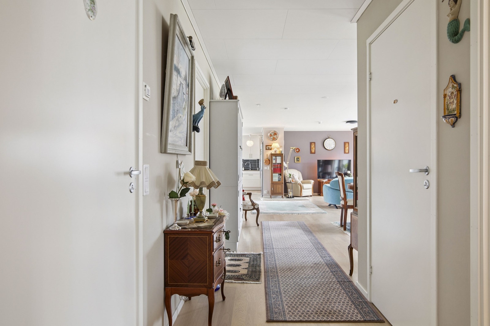 Lys og innbydende gang som binder sammen boligens oppholdsrom på en naturlig måte. Galleribilde