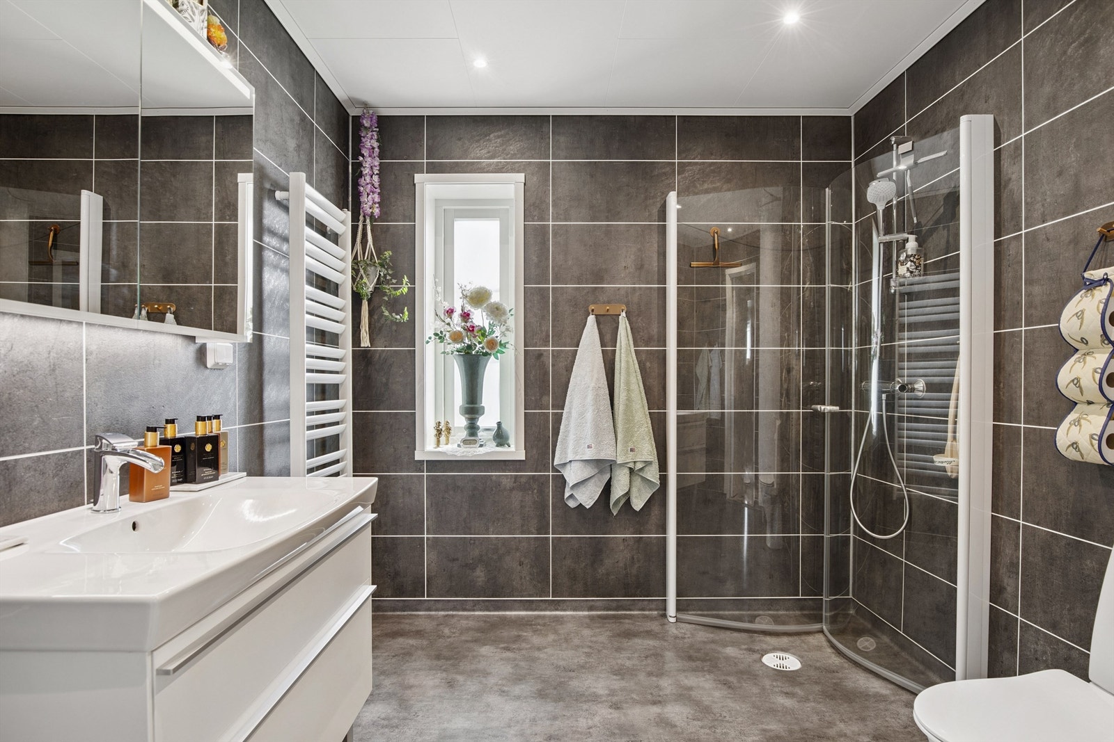 Badet fra 2020 har moderne innredning, toalett, dusjhjørne med innfellbare glassdører og håndklevarmer. Galleribilde