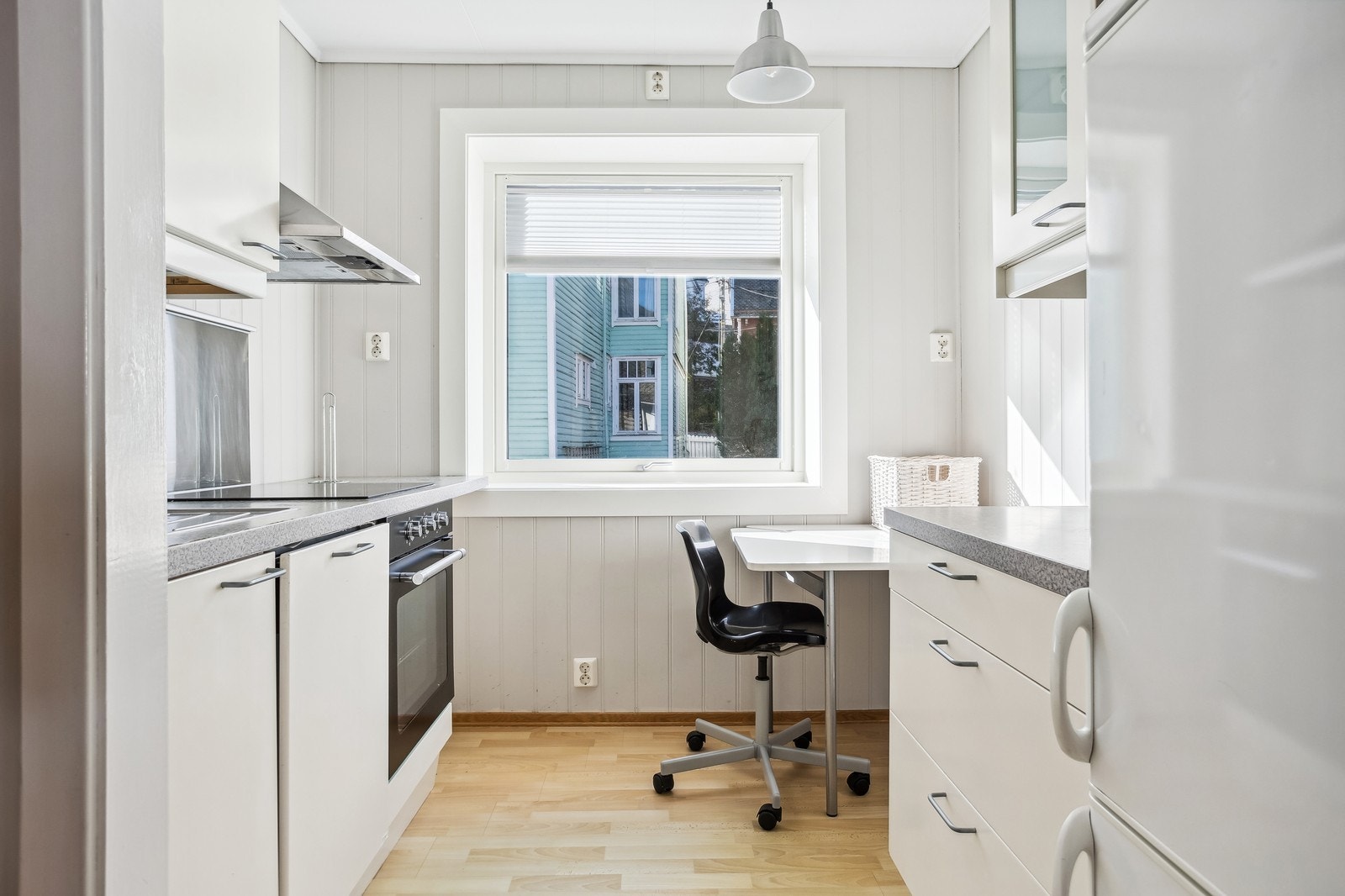 Moderne kjøkkeninnredning med integrert stekeovn, platetopp, oppvaskmaskin og kjøleskap/frys. Galleribilde