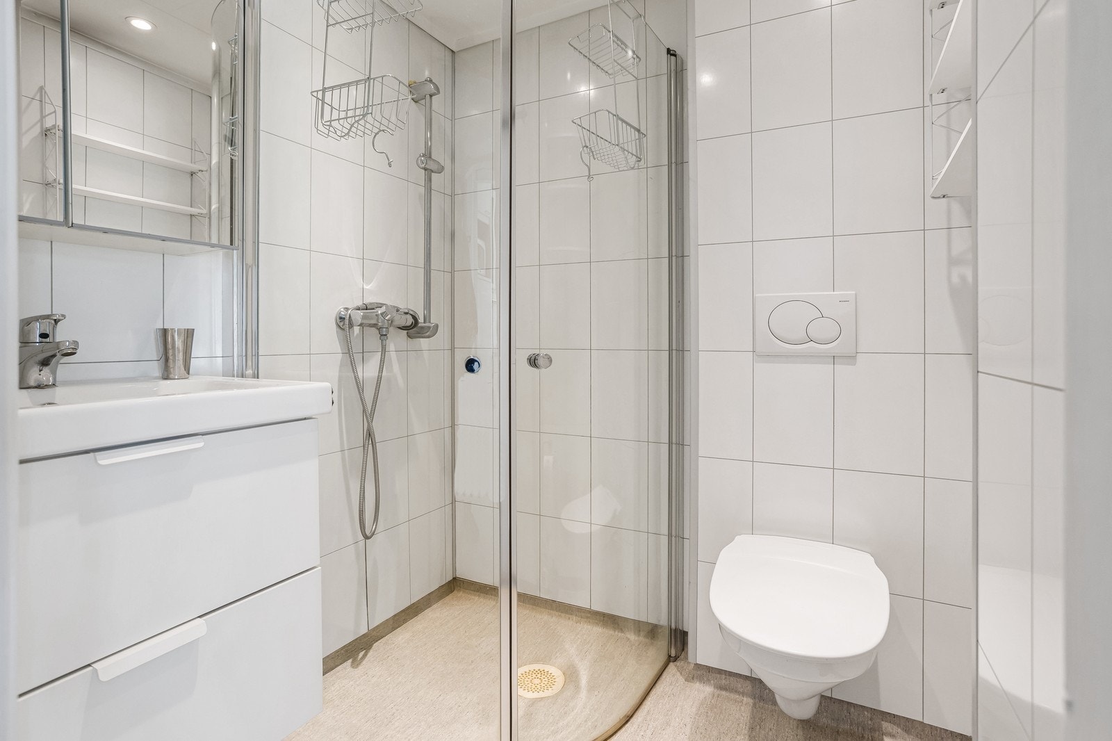 Delikat baderom som er innredet med toalett, servant og dusj. Galleribilde