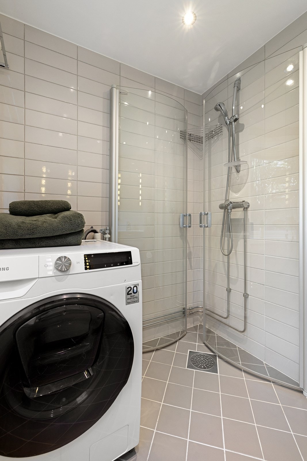 Det er opplegg for vaskemaskin,. Dusjhjørne med innfellbare og plassbesparende glassdører Galleribilde