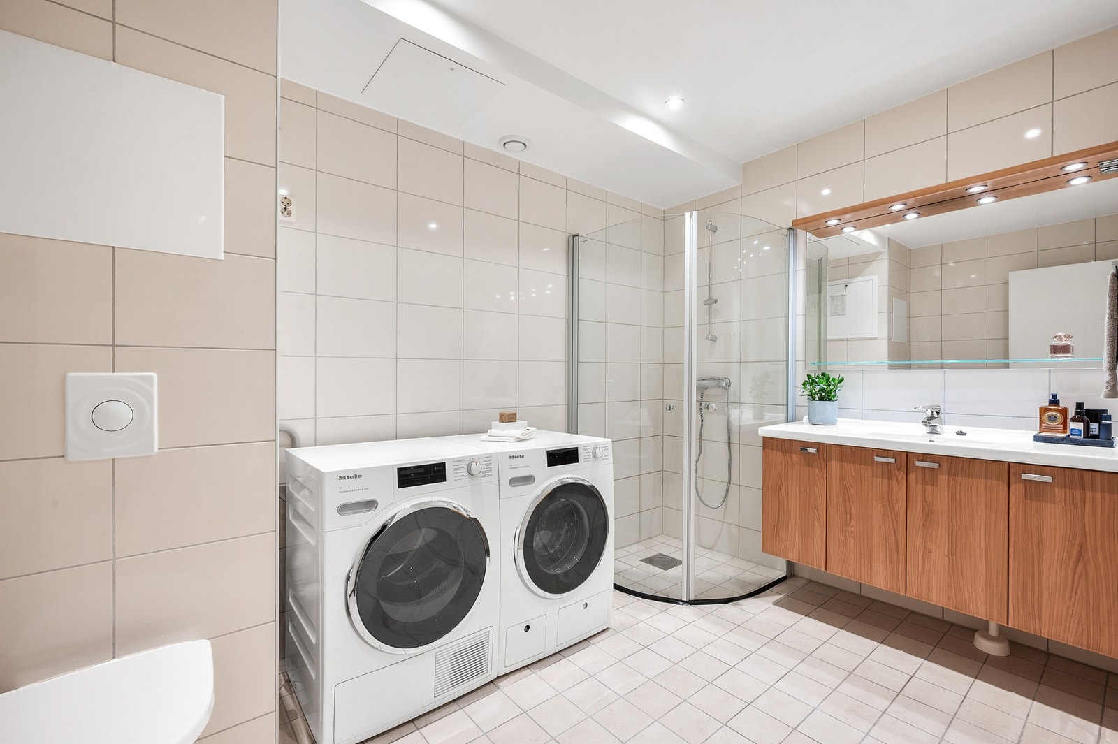 Et lyst og romslig bad med opplegg for både vaskemaskin og tørketrommel. Galleribilde