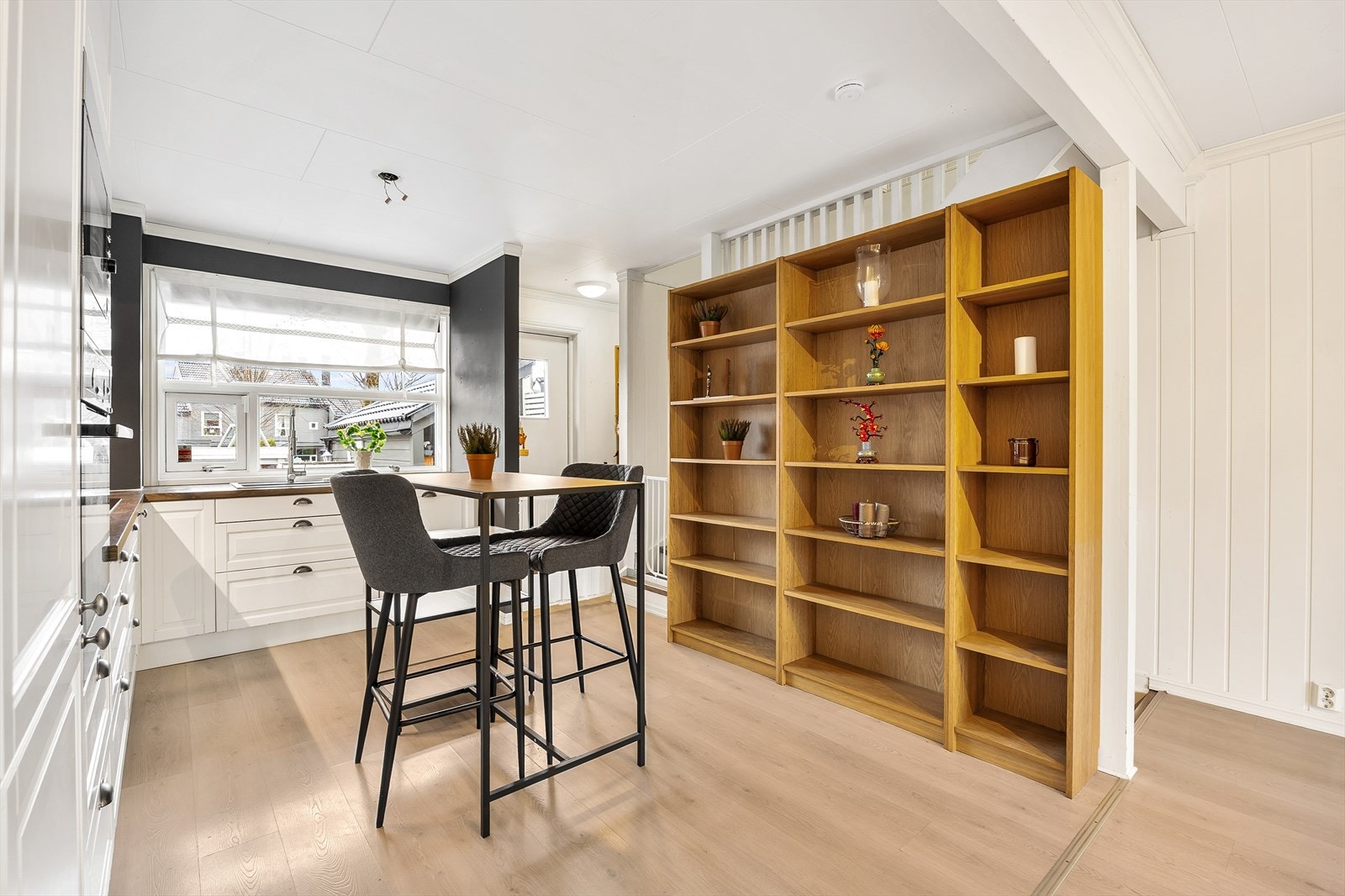 Den åpne hyllen gir ekstra oppbevaring og fungerer som en romdeler. Galleribilde