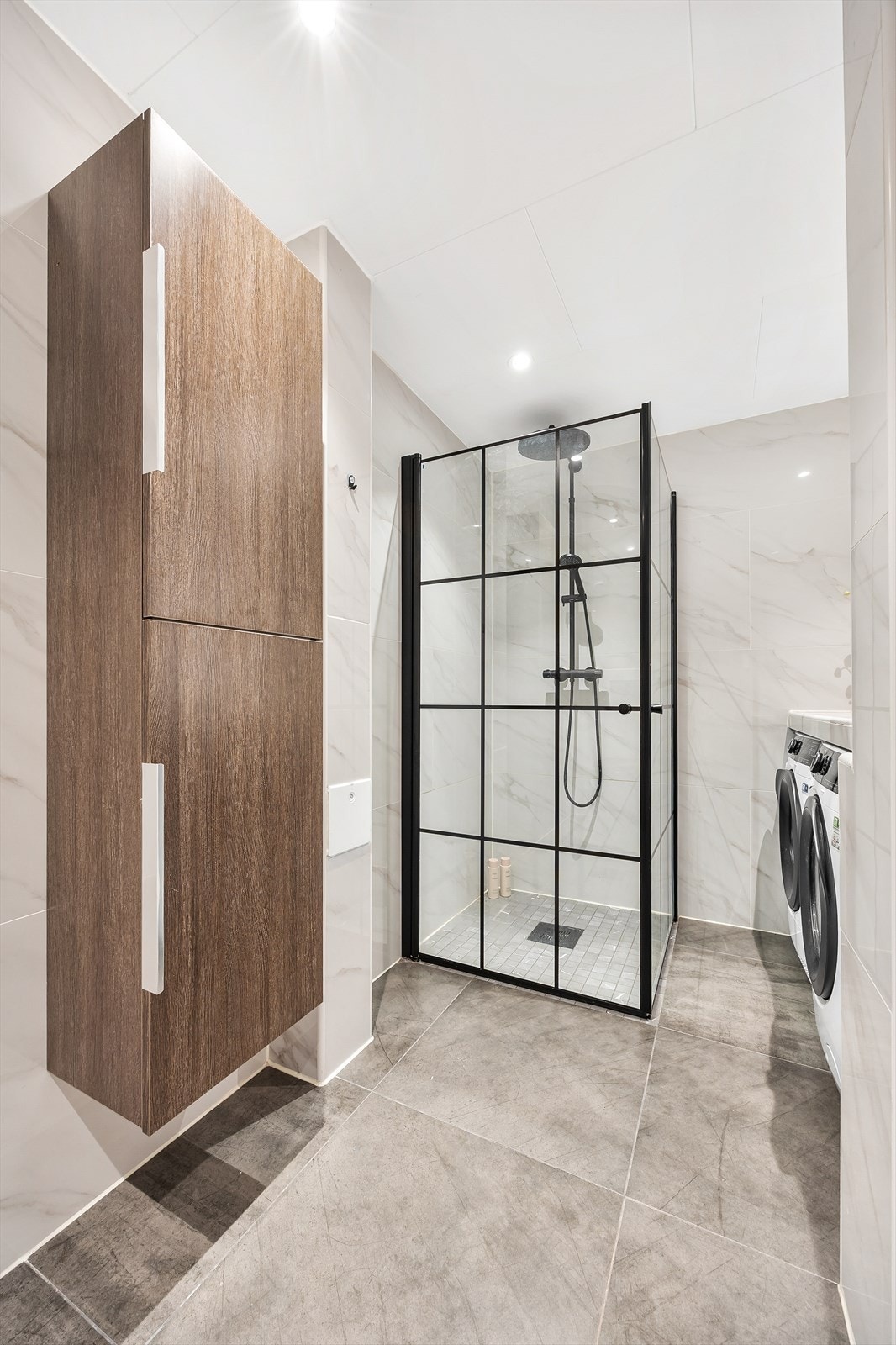 Dusjhjørne med glassvegger og praktisk høyskap for oppbevaring. Galleribilde