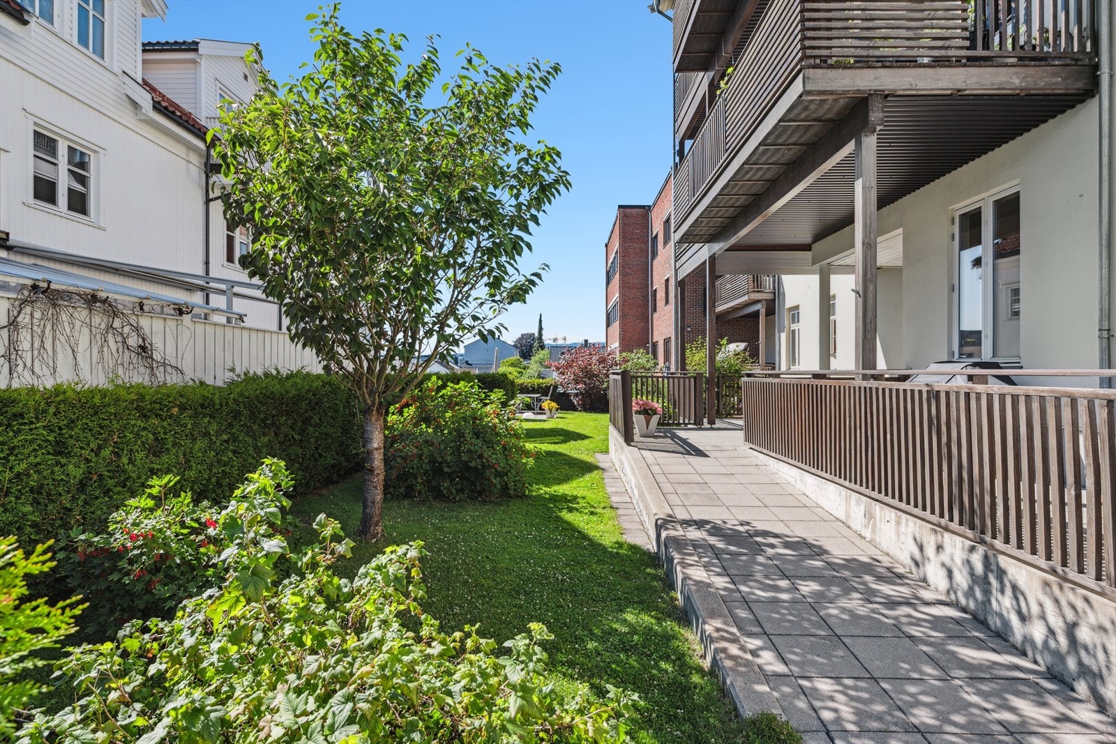 Tomten er opparbeidet med noe gressplen og hekk, som gir et grønt og innbydende uteområde. Galleribilde