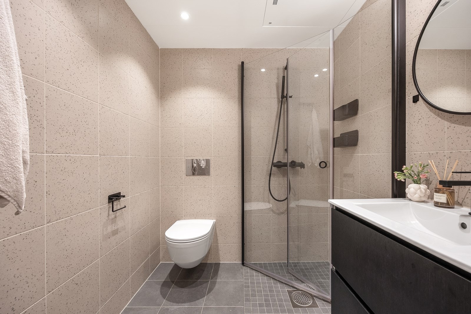 Her er badet utstyrt med dusjhjørne med innfellbare glassvegger, vegghengt wc og servantinnredning med skuffer Galleribilde