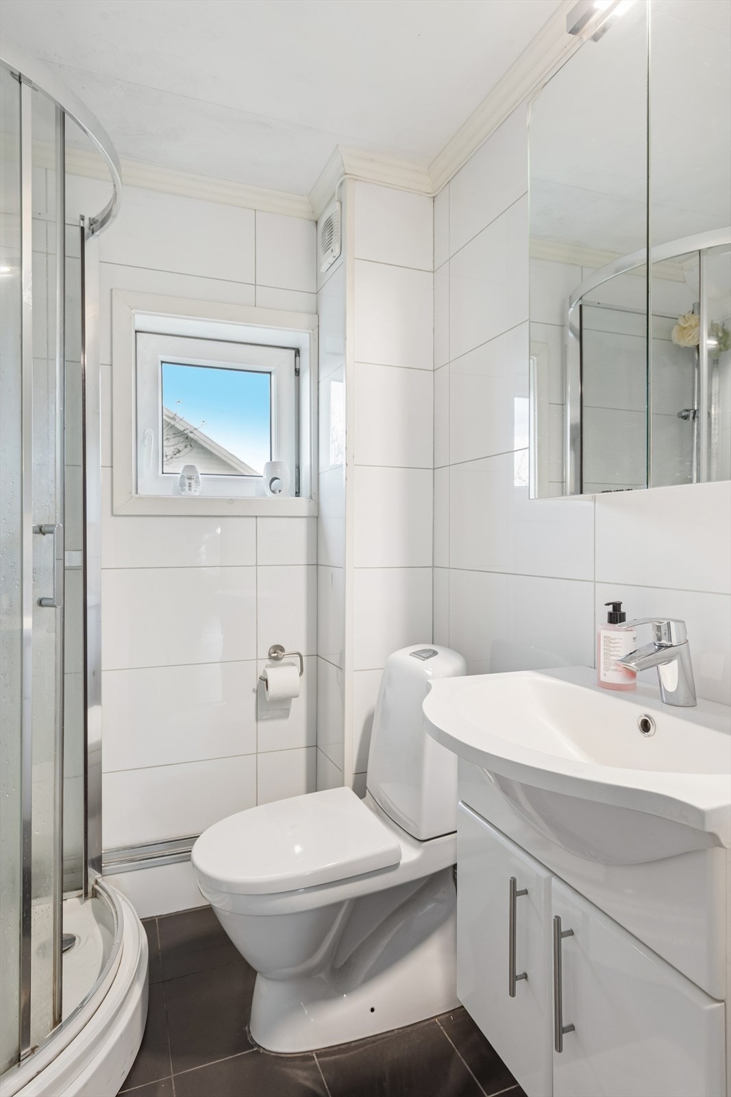 Lyst og pent baderom med opplegg for vaskemaskin. Galleribilde