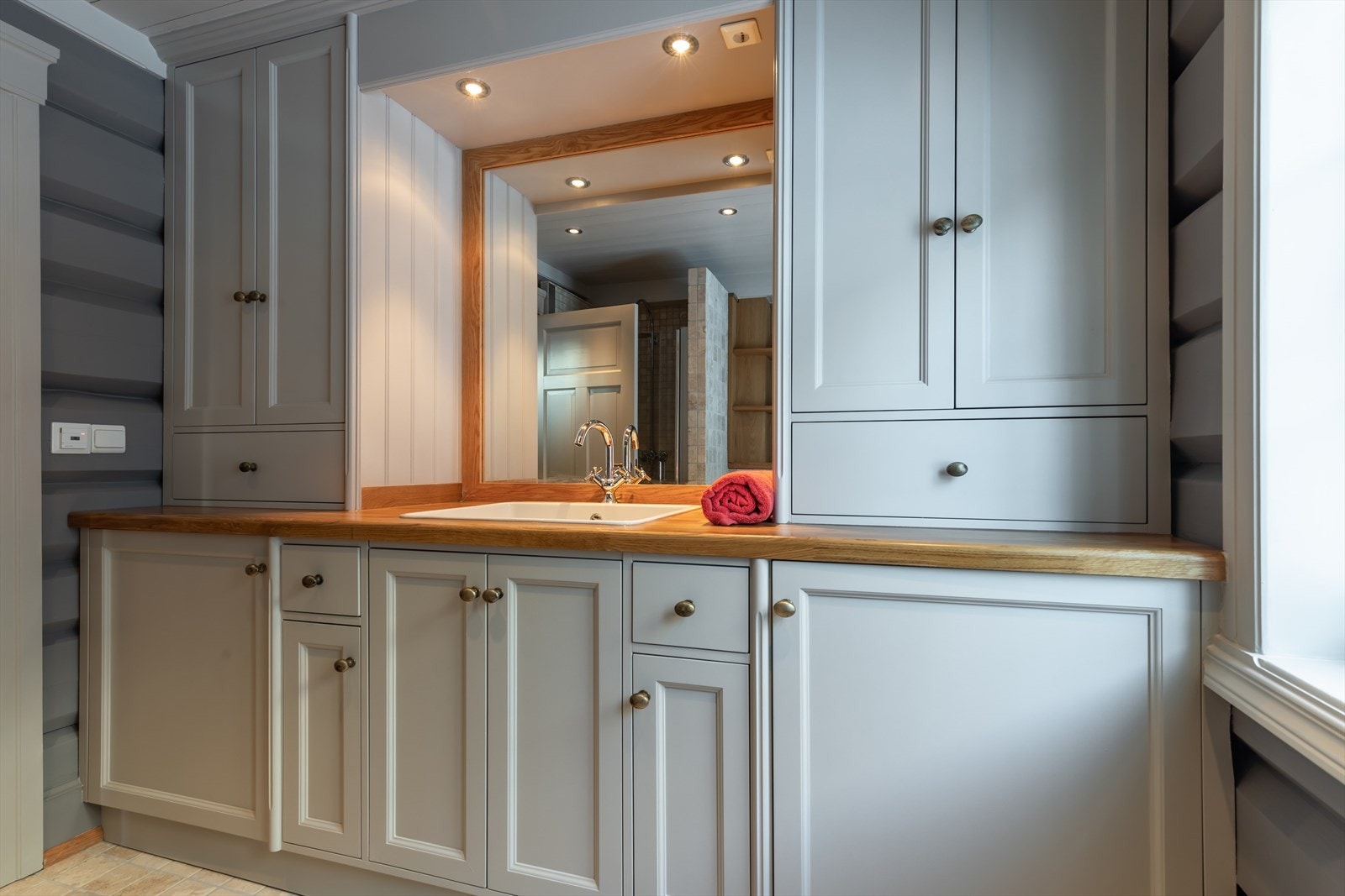 Romslig bad i hovedplan med innredning i Kvänumstil med godt med skapplass Galleribilde