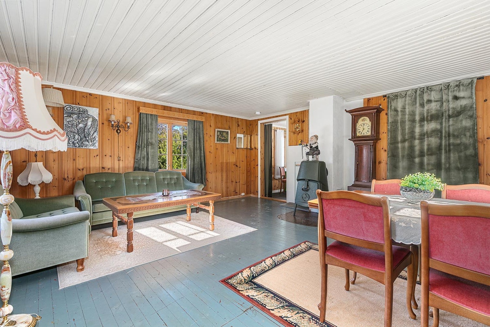 Stuen varmes opp av en hyggelig peisovn som er montert midt i rommet. Galleribilde