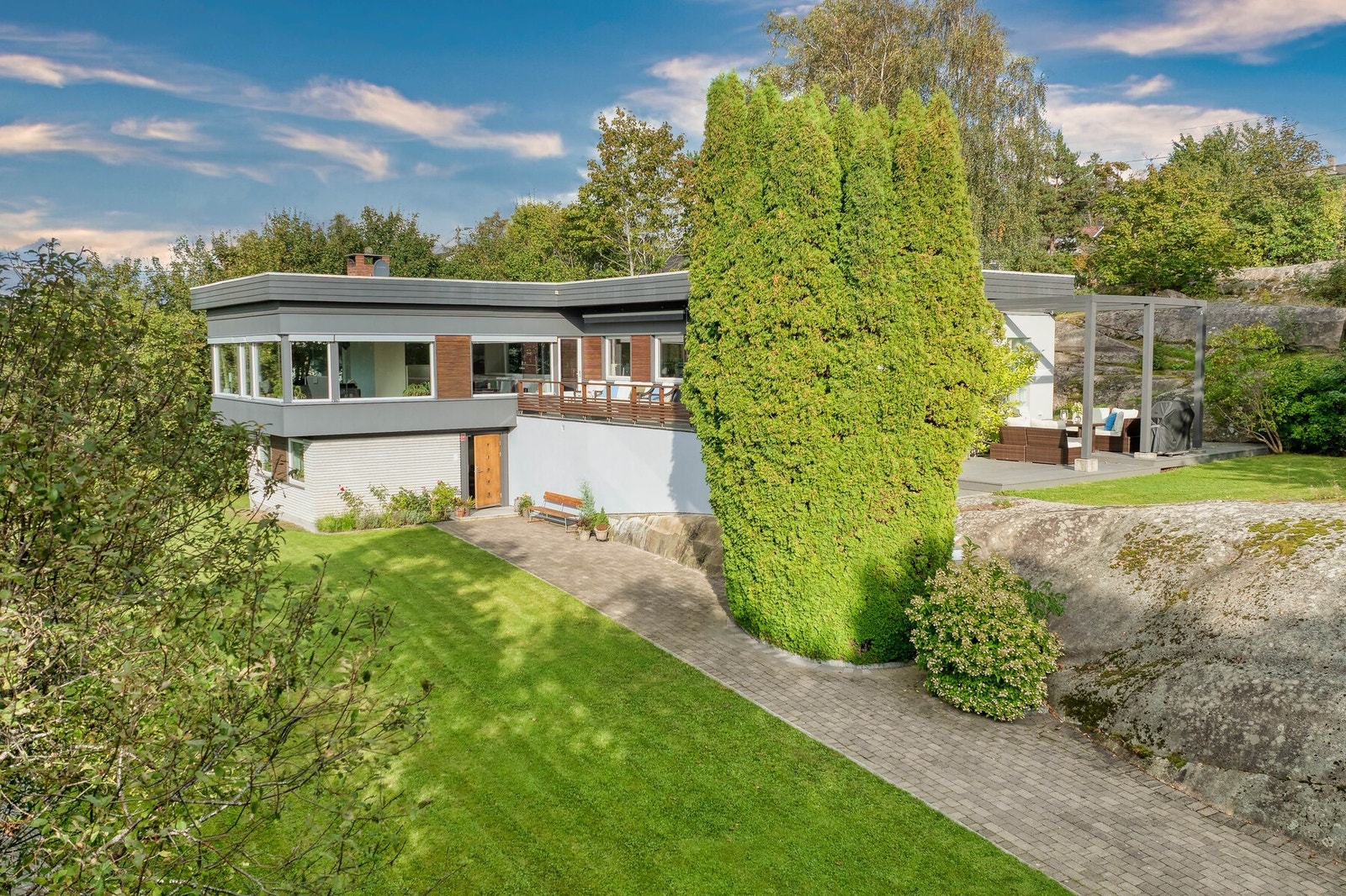 Fra eiendommens adkomst. En stor, solrik tomt med bebyggelse som henvender seg mot ettermiddagssolen. Galleribilde