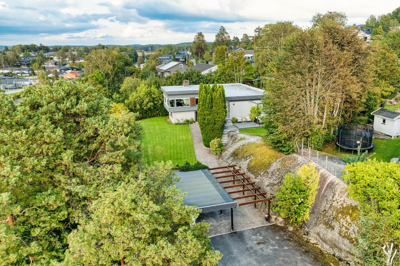 Tpmten er variert, med innslag av fjell, naturtomt og opparbeidet hage. Bebyggelsen er tilpasset tomtens naturgitte muligheter. Galleribilde