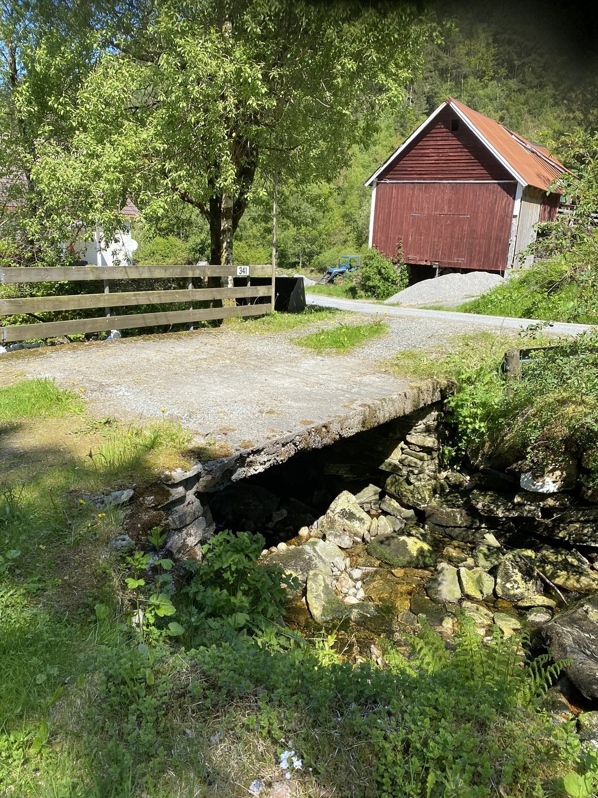 Adkomst over bekk med bro fra hovedvei Galleribilde