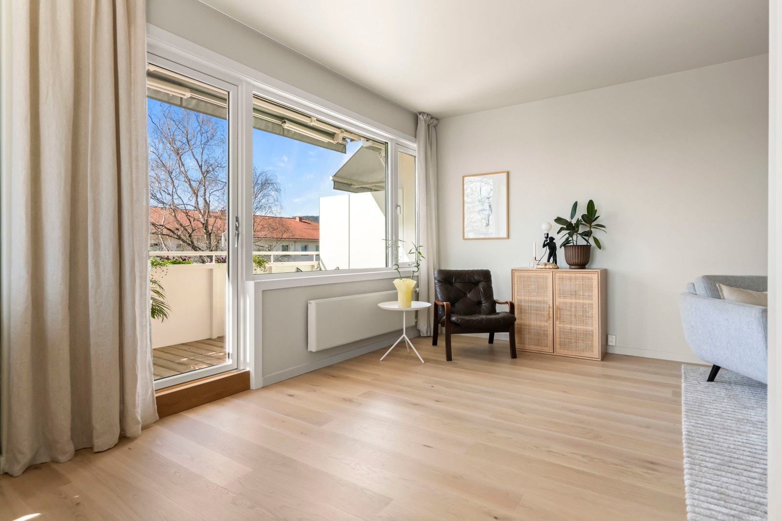 Stor lys stue med vinduer og balkongdør mot vest. Galleribilde