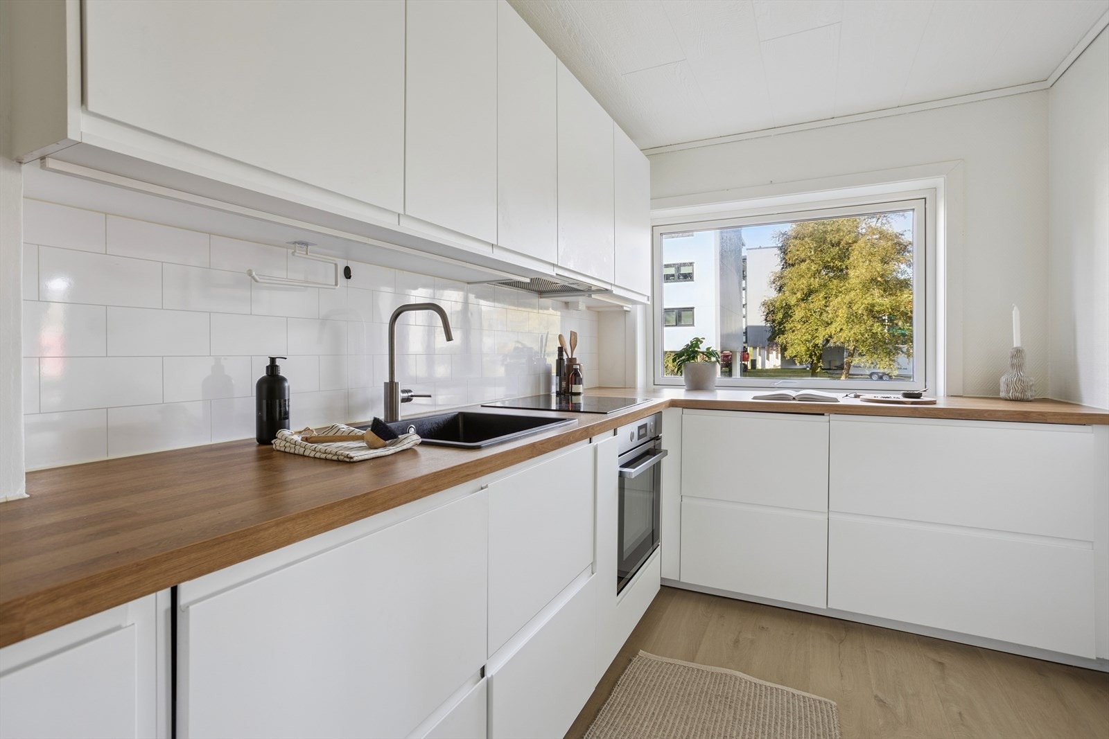 Kjøkkenet er ca. 7,9 kvm og oppgradert i 2022, med moderne IKEA-innredning. Her får du slette, lyse fronter, laminat benkeplater og komposittvask. Galleribilde