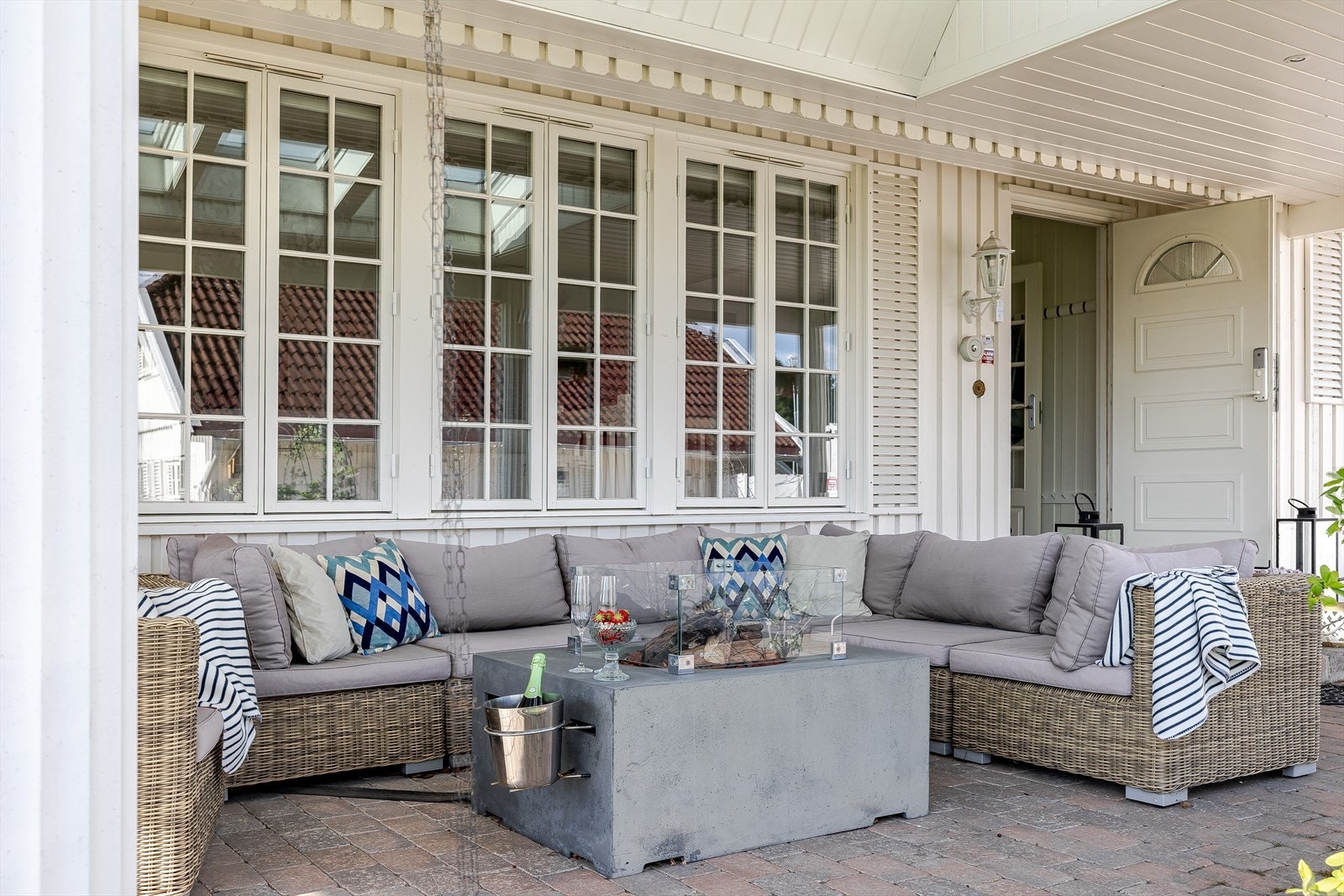 Overbygget uteplass ved inngangspartiet med god plass til stor sofagruppe. Galleribilde