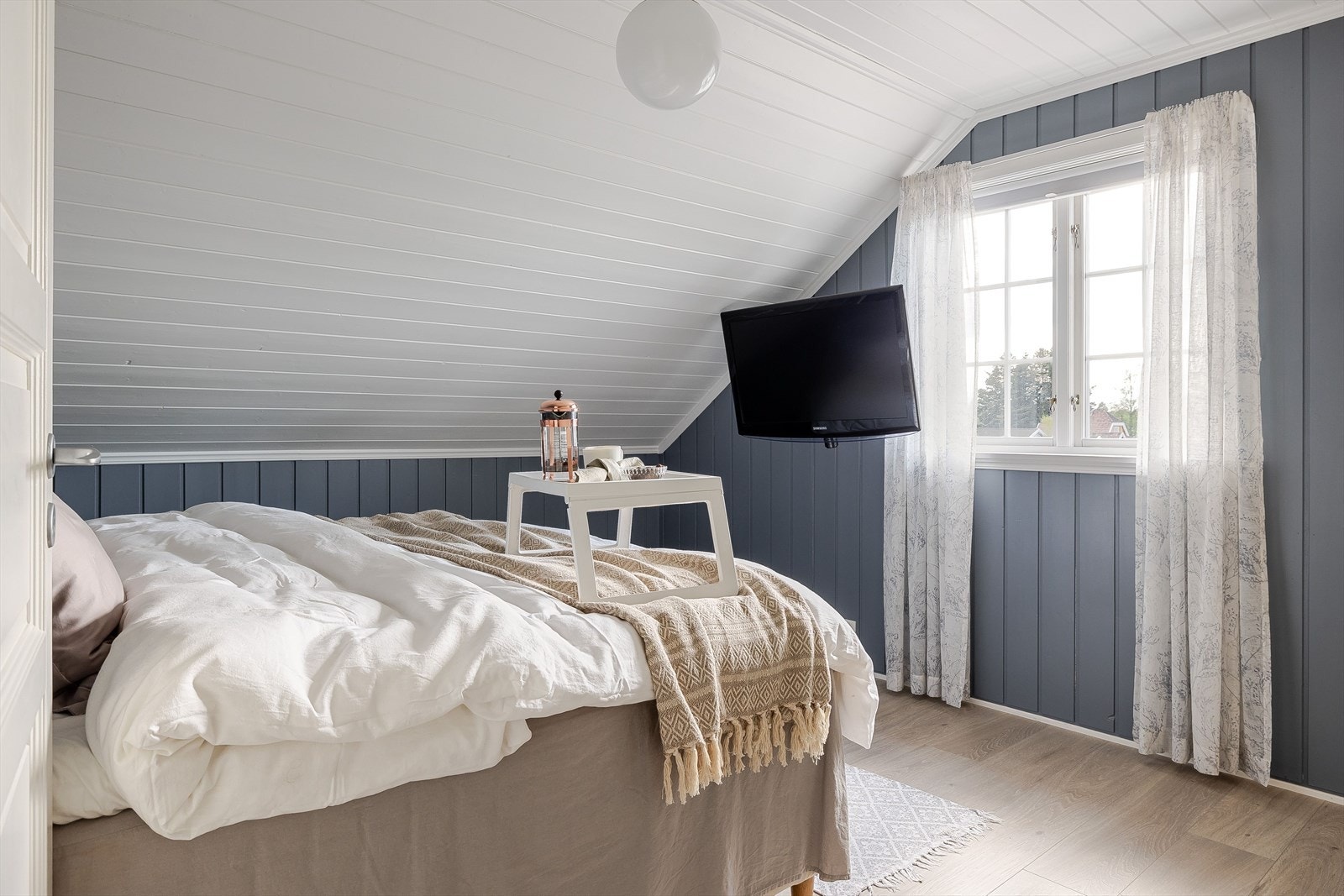 Lyst og innbydende hovedsoverom med tilknytning til et romslig garderoberom. Galleribilde