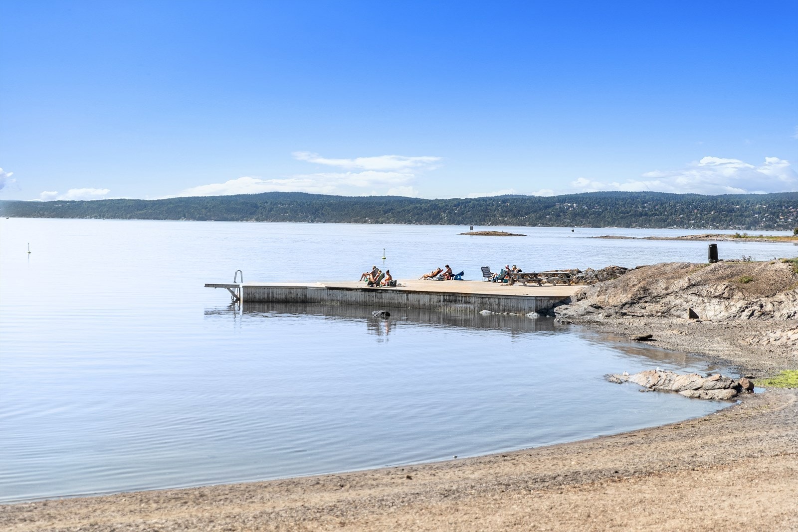 Stranden byr på; sandstrand med langgrunnt vann, stupetårn og flytebrygge og benker, grillplass og piknikmuligheter. Galleribilde