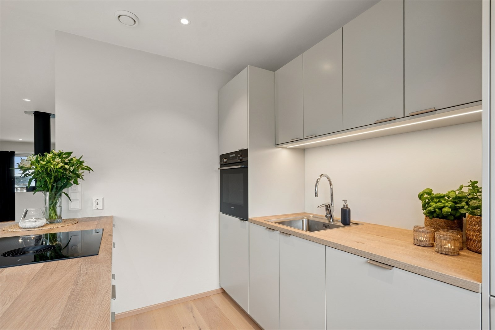 Kjøkkenet har en stilren innredning med glatte fronter og slitesterke laminat benkeplater som gir et rent og moderne uttrykk. Galleribilde