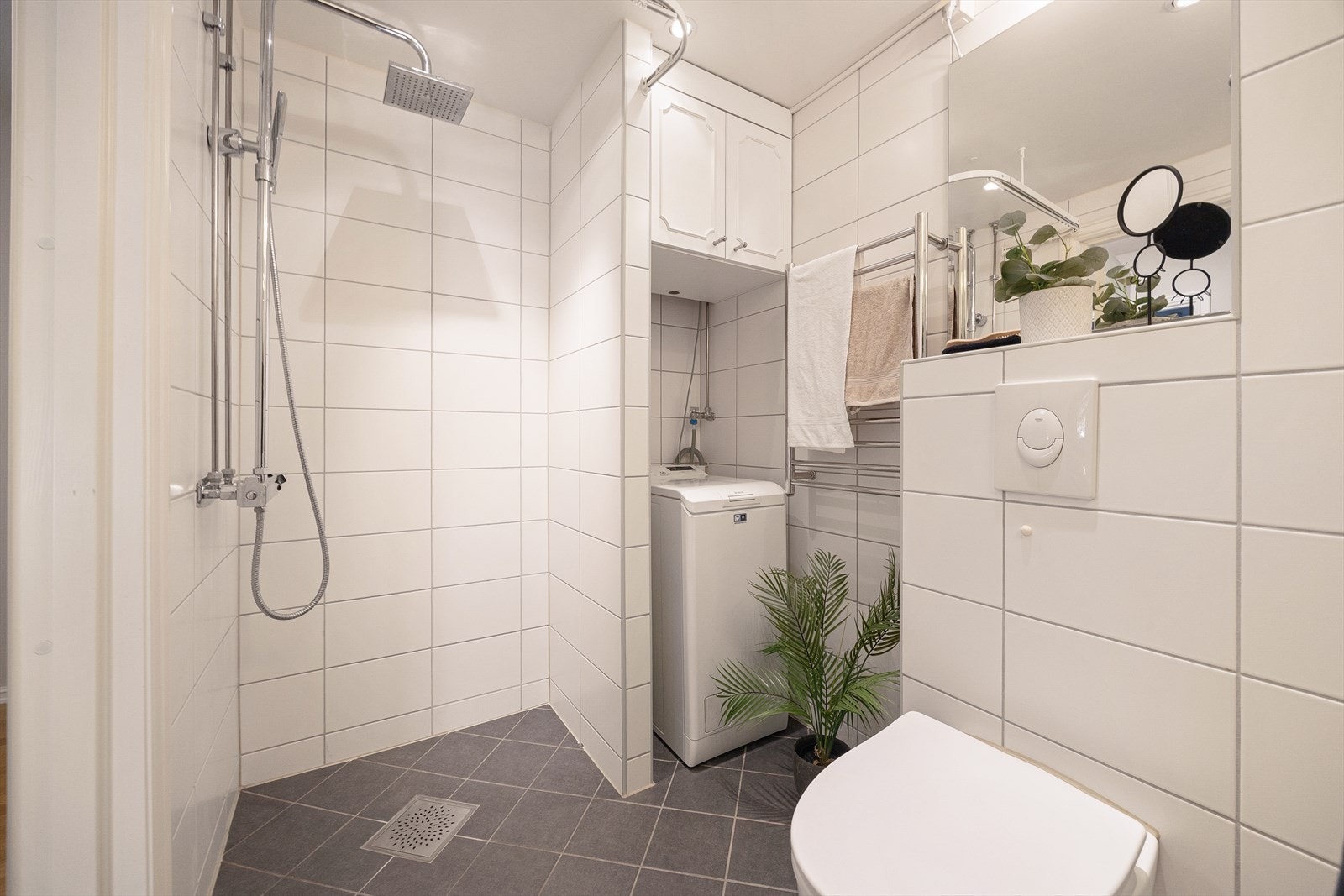 Badet består blant annet av dusjnisje, toalett, servant med innredning og opplegg for vaskemaskin. Galleribilde