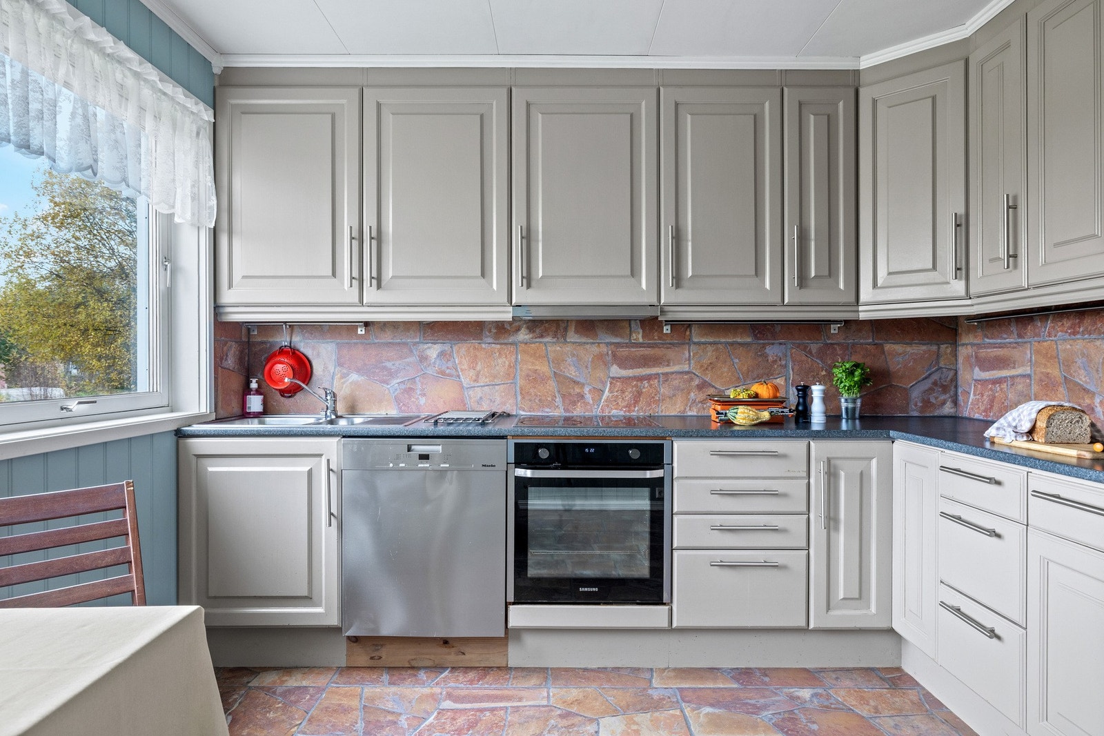 Boligen har separat kjøkken med innredning fra 2007. Kjøkkenet har malte profilerte fronter i en nøytral beige tone og benkeplate i laminat. Galleribilde