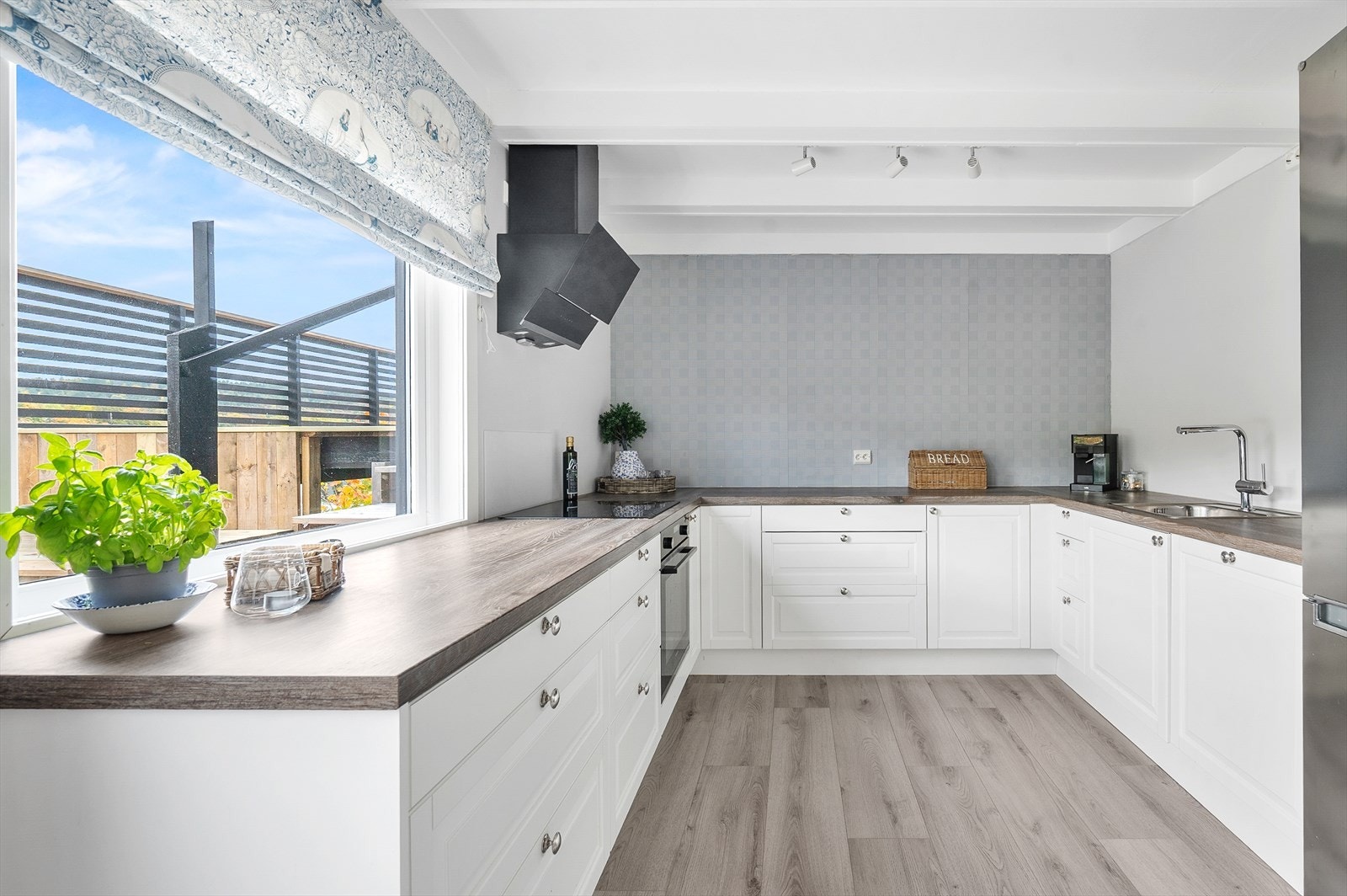 Lyst kjøkken med god benkeplass og profilerte fronter. Galleribilde