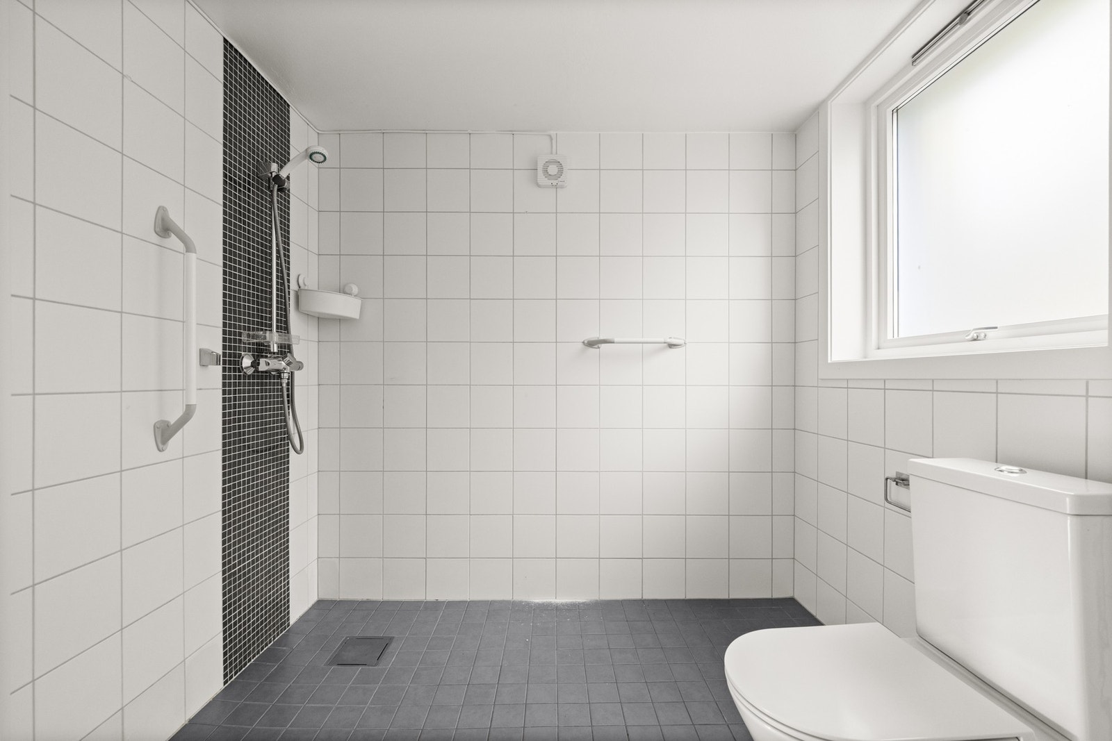 Praktisk bad med fliser, gulvvarme og dusjsone. Galleribilde