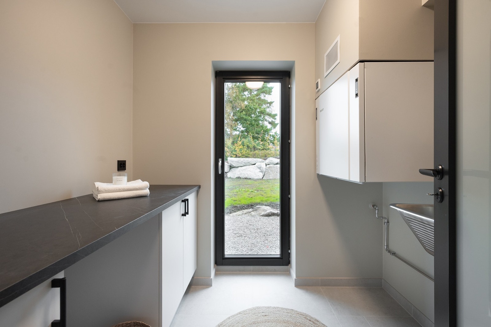 Vaskerommet har egen praktisk utgang til hagen gjennom en glassdør. Galleribilde