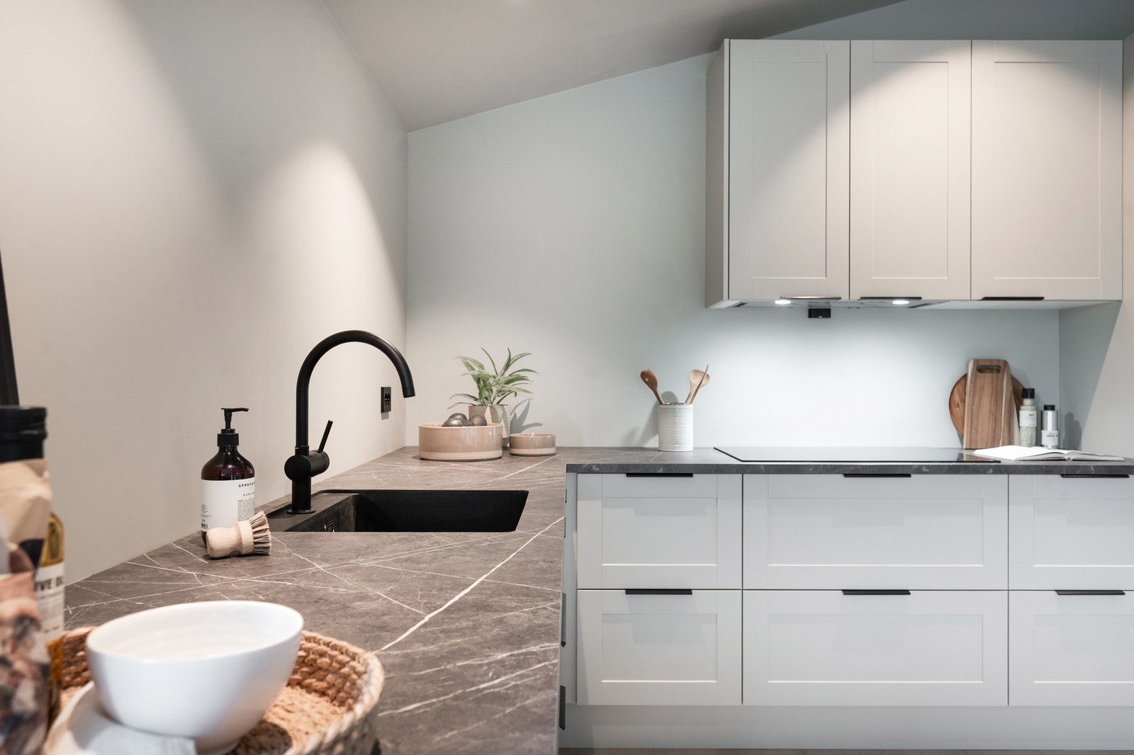 Benkeplaten er mørk grå marmor laminat. Underlimt vask med stort armatur. Galleribilde