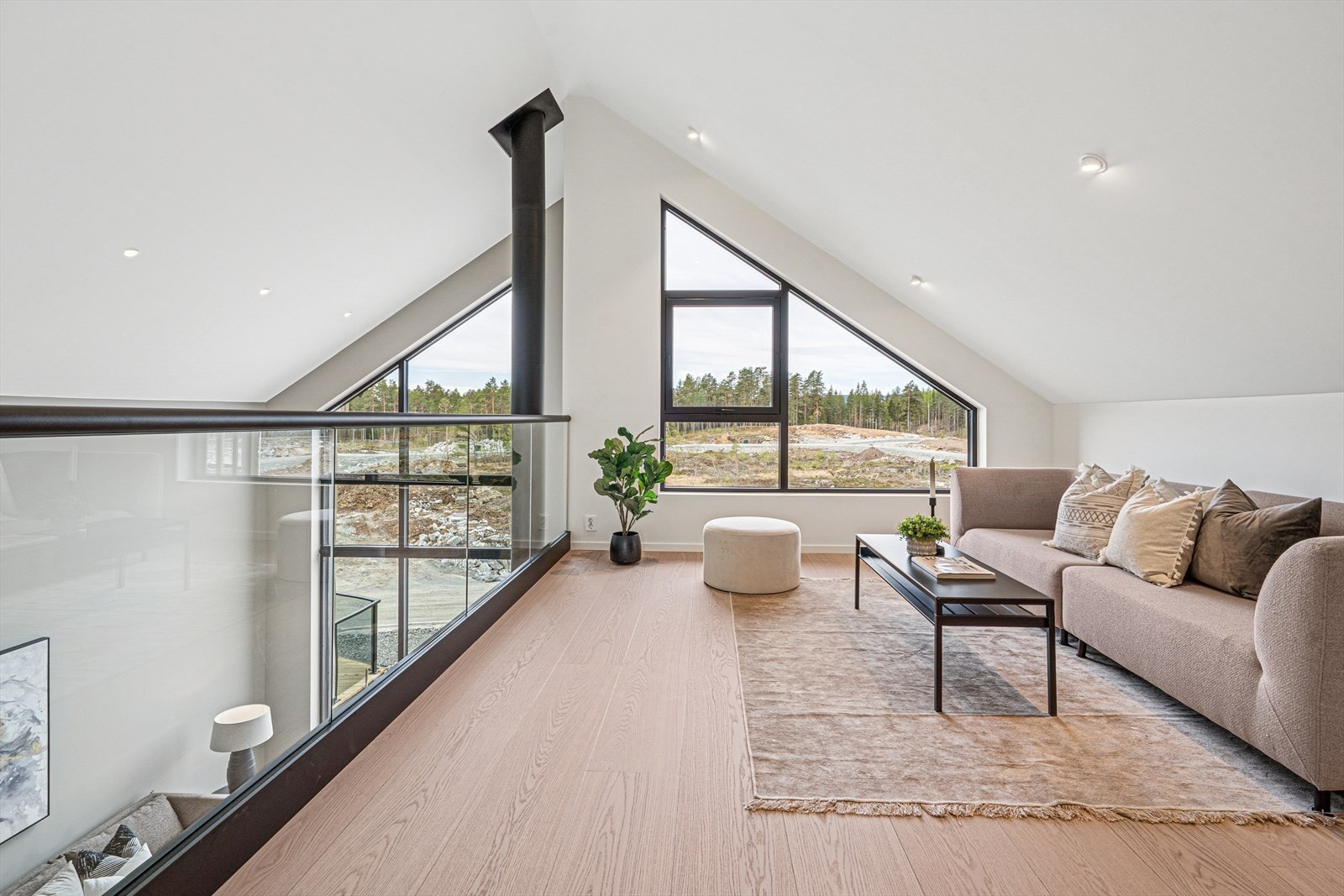 En lys og luftig stue med imponerende panoramavinduer som slipper inn rikelig med naturlig lys og gir en pen utsikt over landskapet. Galleribilde