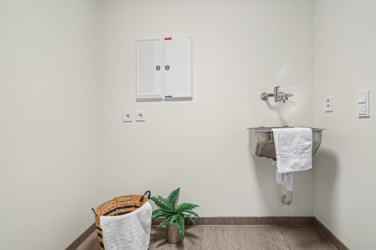 Vaskerom med skyllekar, varmtvannsbereder, opplegg for vaskemaskin, vannfordelerskap, sikringsskap og ventilasjonsagregat. Galleribilde