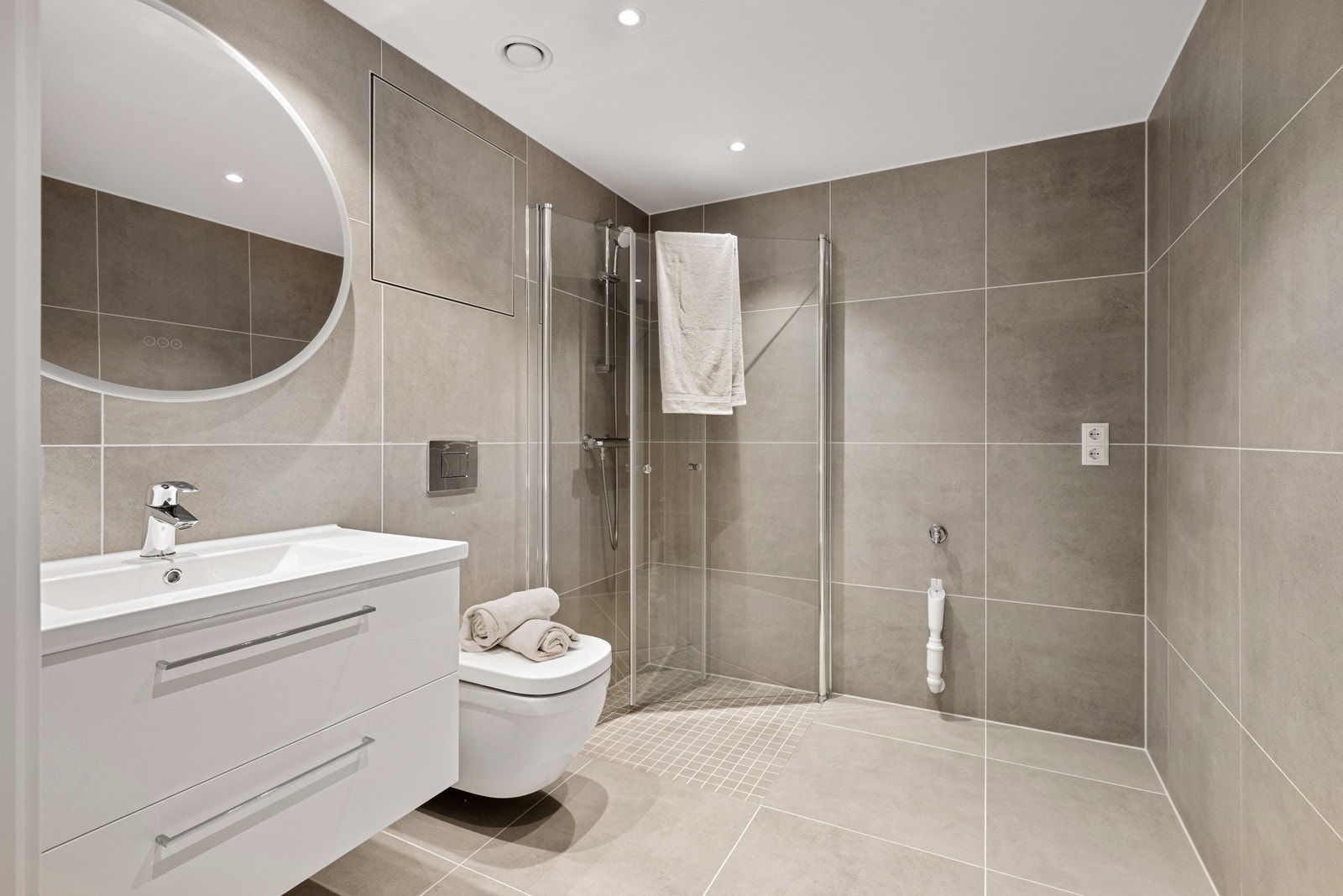 Badet fremstår som delikat og moderne, med fliser på både gulv og vegger som gir et helhetlig og stilrent uttrykk. Galleribilde