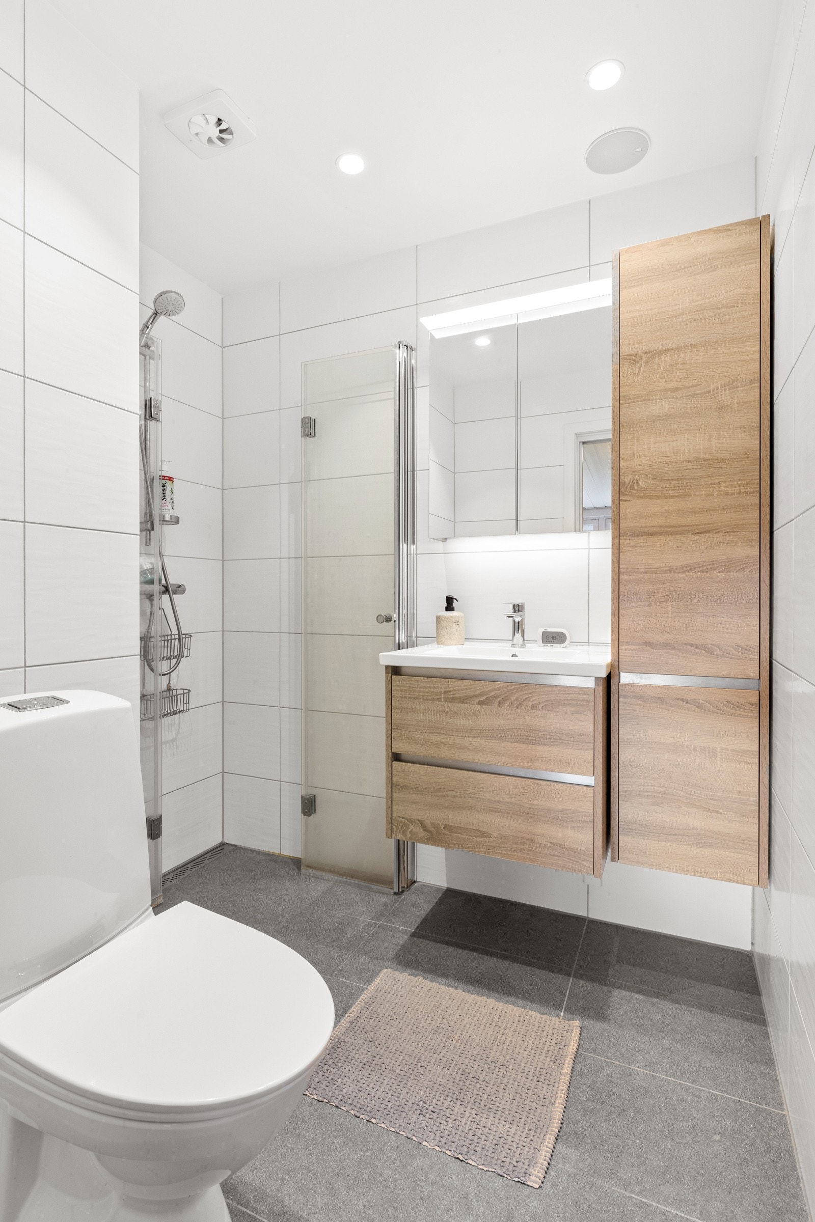 Flislagt bad med dusjhjørne, toalett og servantinnredning. Elektrisk gulvvarme gir behagelig komfort. Galleribilde