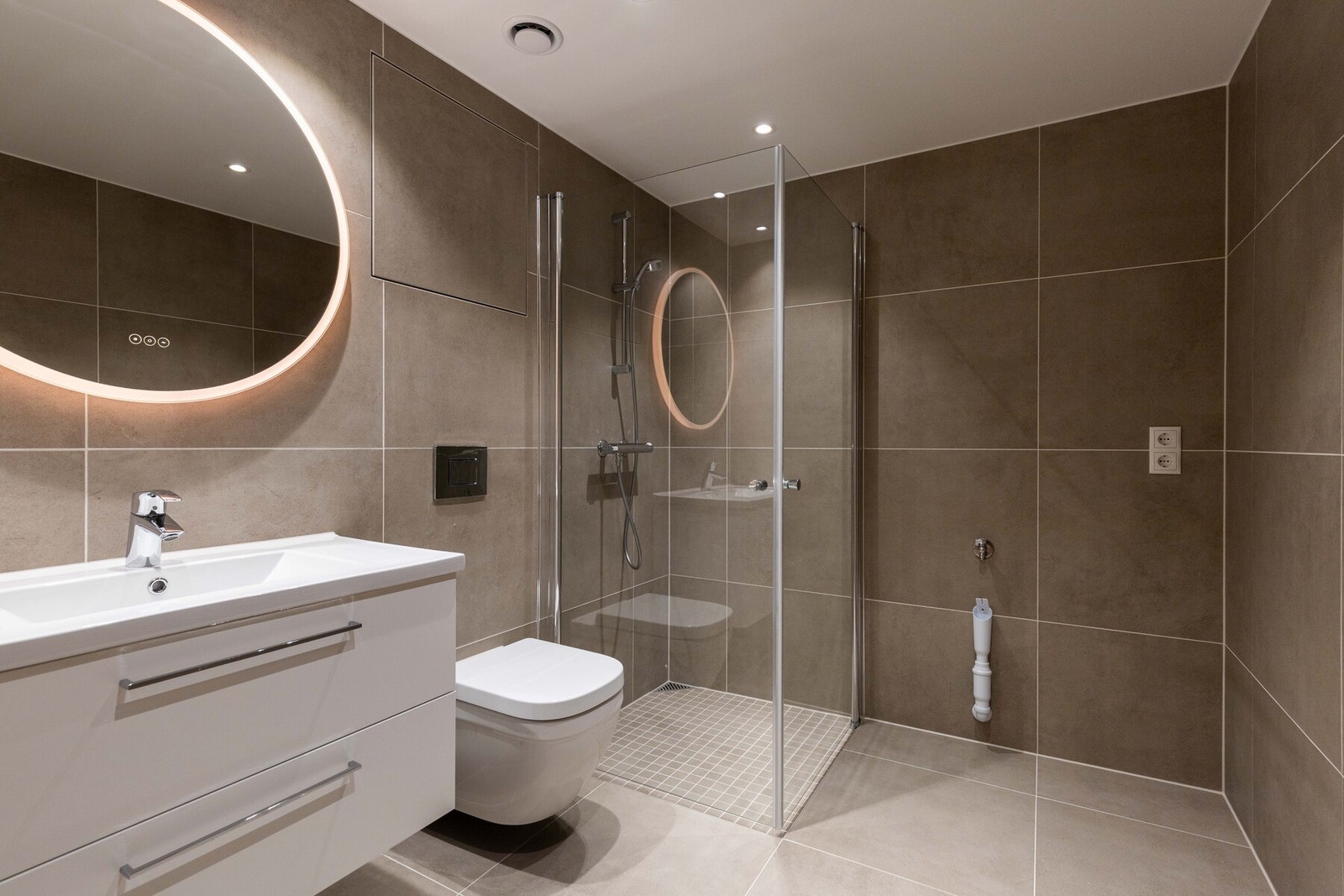 Her er det varmekabler i gulv, dusjhjørne, servant og vegghengt toalett. Galleribilde