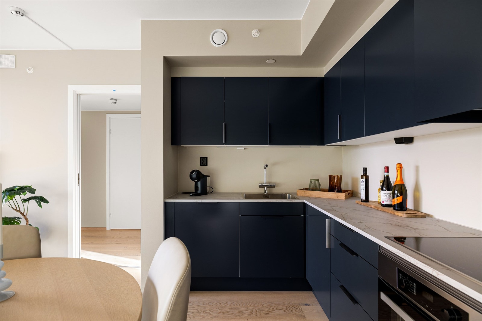 Lett tilgjengelige oppbevaringsmuligheter kombinert med arbeidsflater rundt både vask og platetopp gjør kjøkkenet praktisk i daglig bruk. Galleribilde