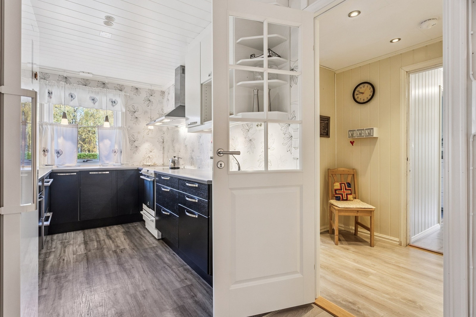 En dør med glassfelt skiller kjøkkenet fra gangen og slipper inn ekstra lys. Galleribilde