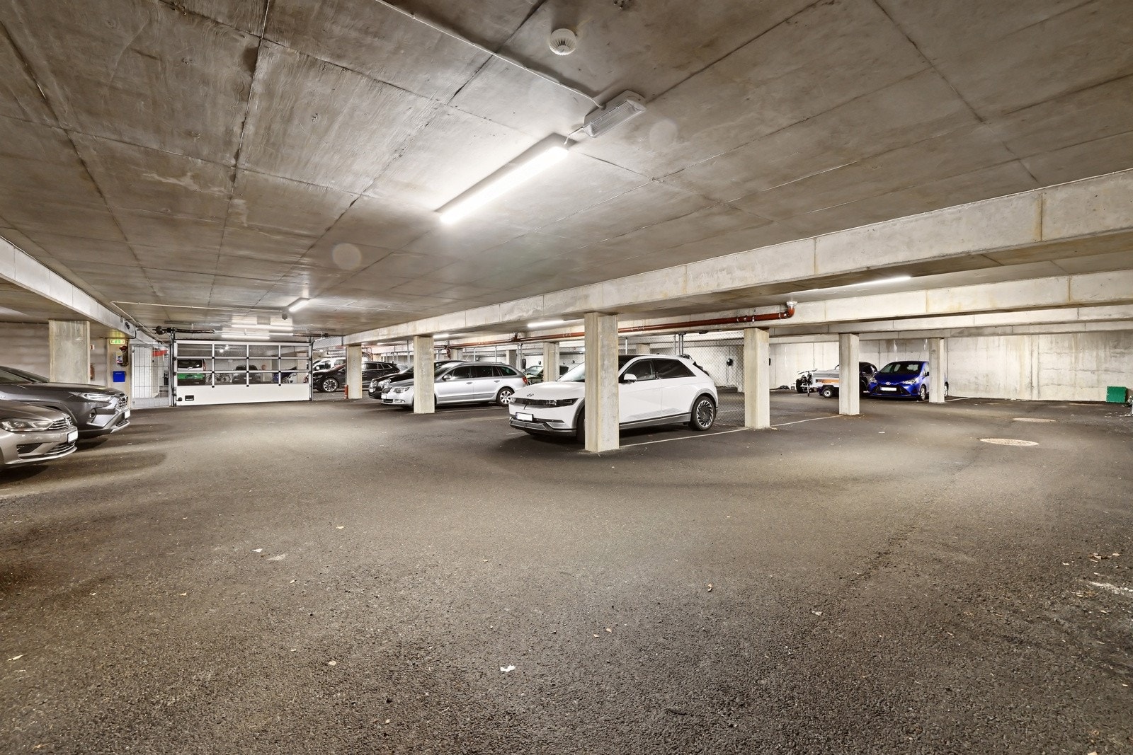 Parkering i fellesgarasje. Leiligheten disponerer også en ekstern bod i fellesareal. Galleribilde