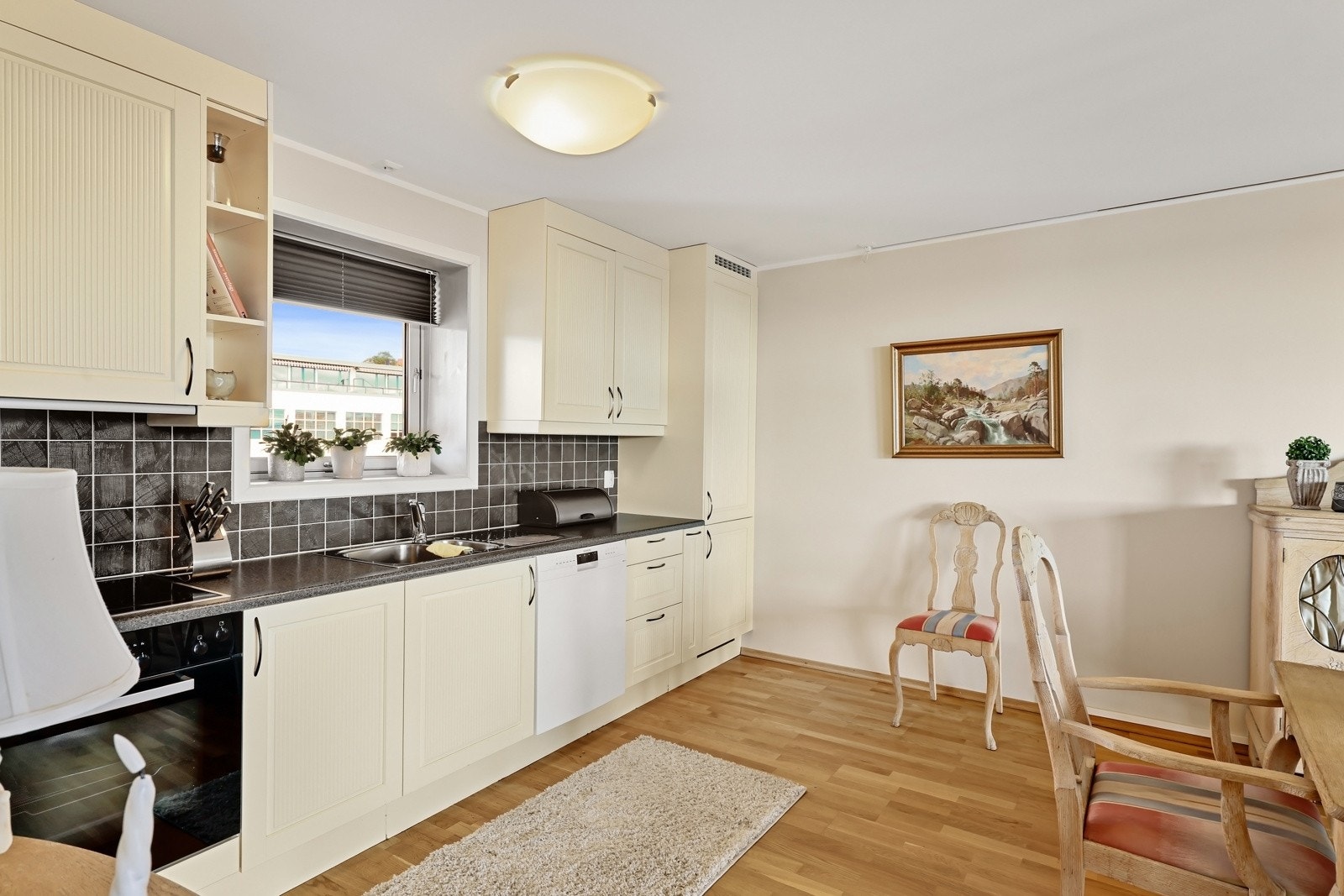 Kjøkkenet har lys innredning med profilerte fronter og benkeplate av laminat. Galleribilde