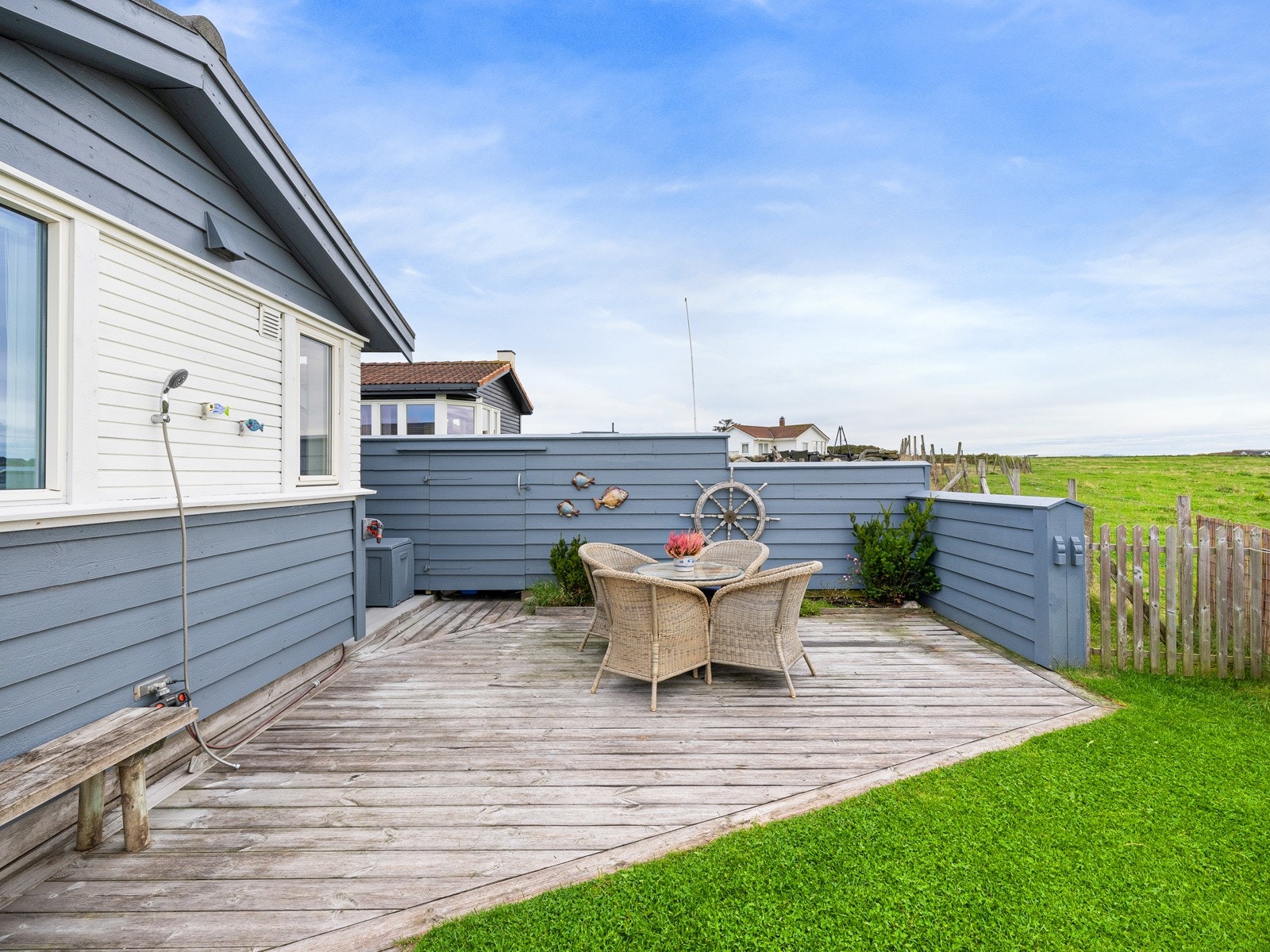 Tilbaketrukket og skjermet terrasse med levegger. Utedusj er montert på vegg, praktisk etter en flott strandtur. Her kan man nyte fantastiske solnedganger og følge med på kitere og bølgesurfere. Galleribilde