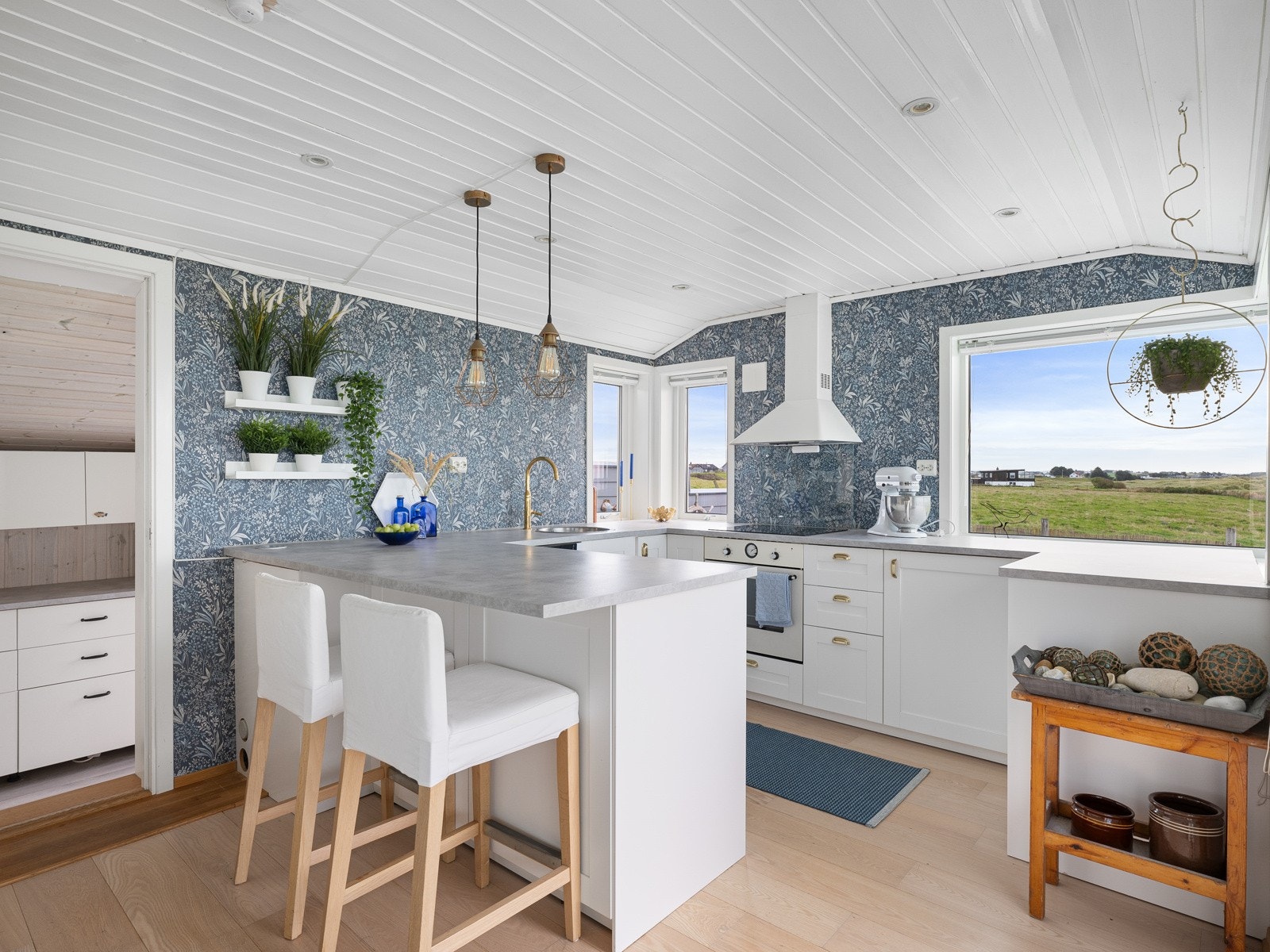 Lyst og tidløst kjøkken som gir god benkeplass og oppbevaring i moderne utførelse. Galleribilde