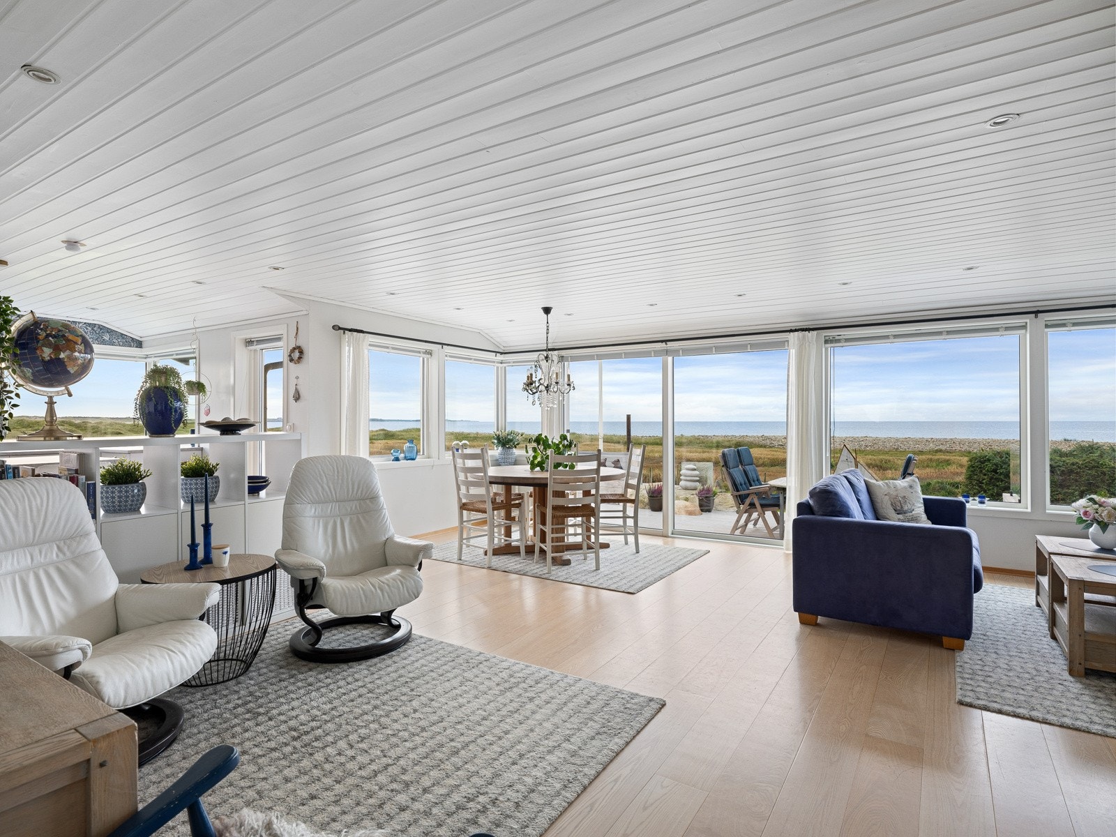 Lyse og flotte omgivelser med en stavs parkett på gulv, panel i tak og store vindusflater. Galleribilde