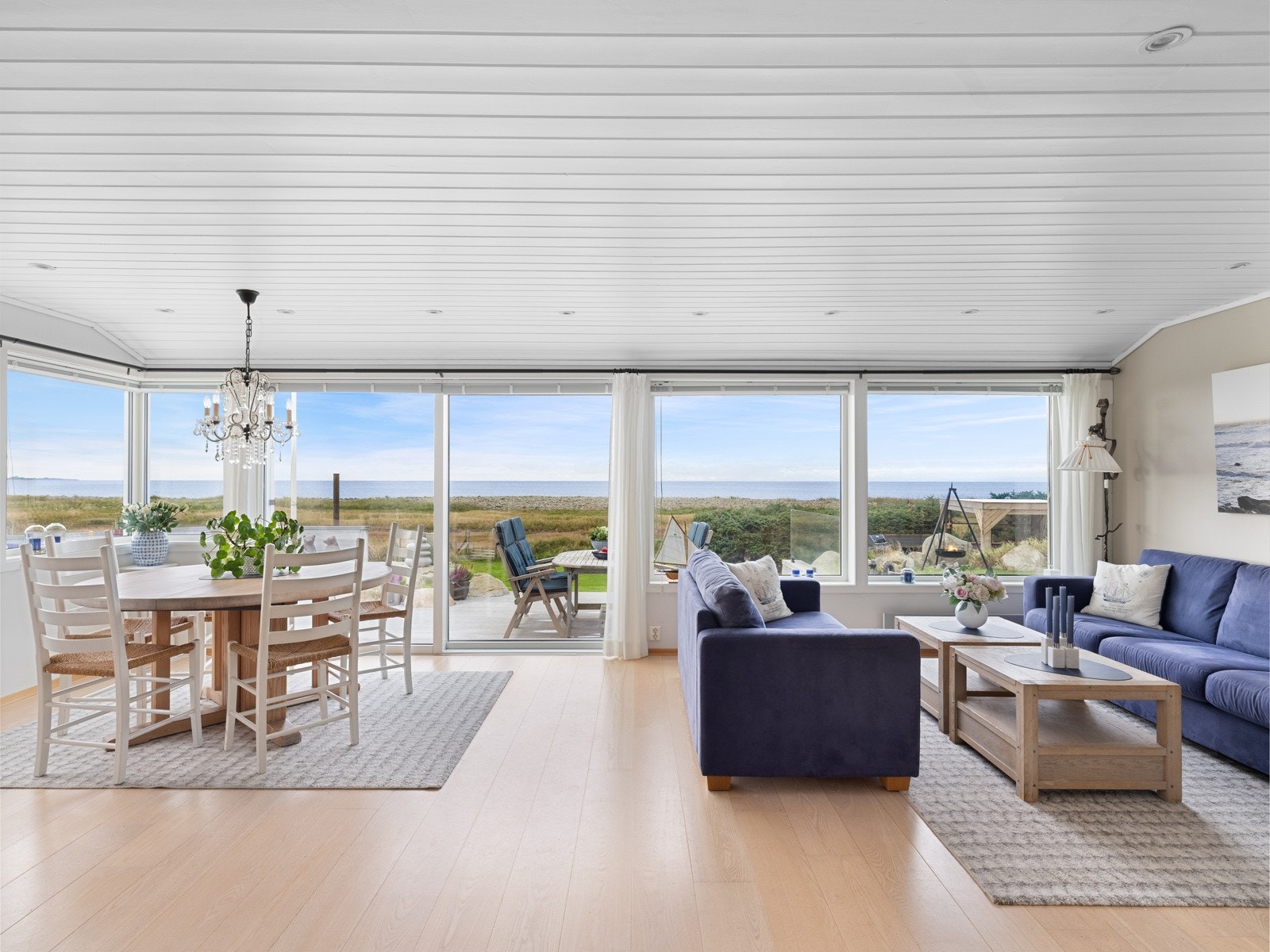 Velkommen inn! På en slik eiendom ønsker man å nyte utsikten fra hytten, og derfor ble det satt inn vinduer fra gulv til tak, der man får havet rett foran seg. Galleribilde