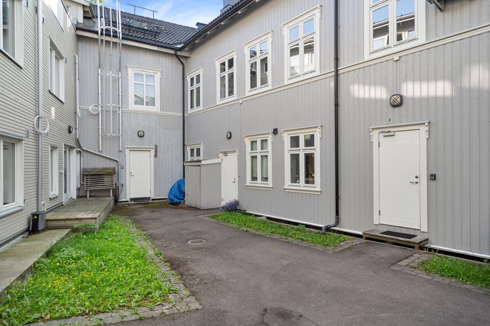 Rolig bakgård med adkomst - oppgangen er den hvite døra i midten Galleribilde